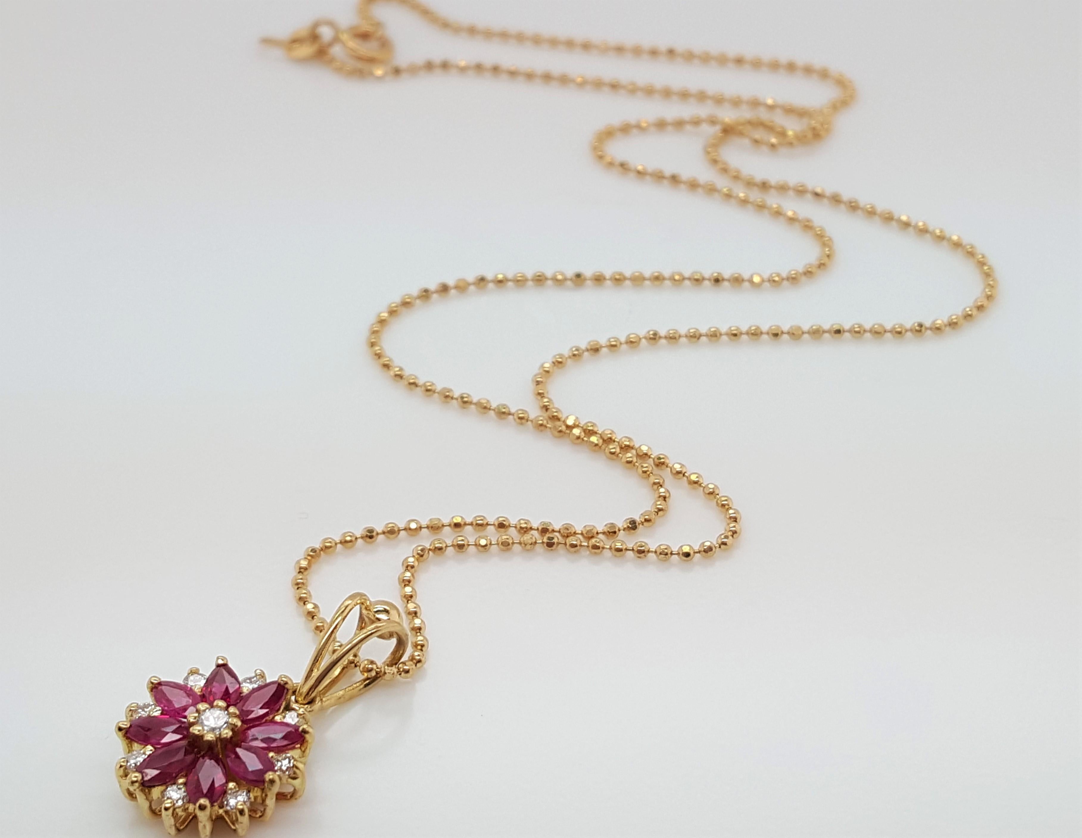 18K Yellow Gold Flower Motif Diamond and Ruby Pendant with Chain.  The delicate pendant depicting a flower features eight bright red marquise shaped rubies weighing approximately  0.40 carats total weight, set into prongs, enhanced by full cut round