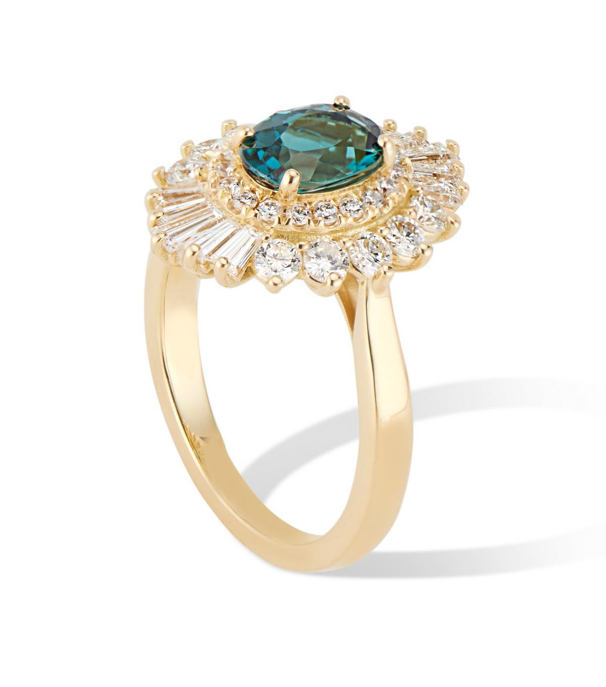 The Flutter Ballerina Ring is inspired by the roaring 20’s Art Deco period combined with a nod to the 80’s Ballerina, creating a ring that is glamorous, decadent, and romantic. 
The eye catching blue -green tourmaline center surrounded firstly by an