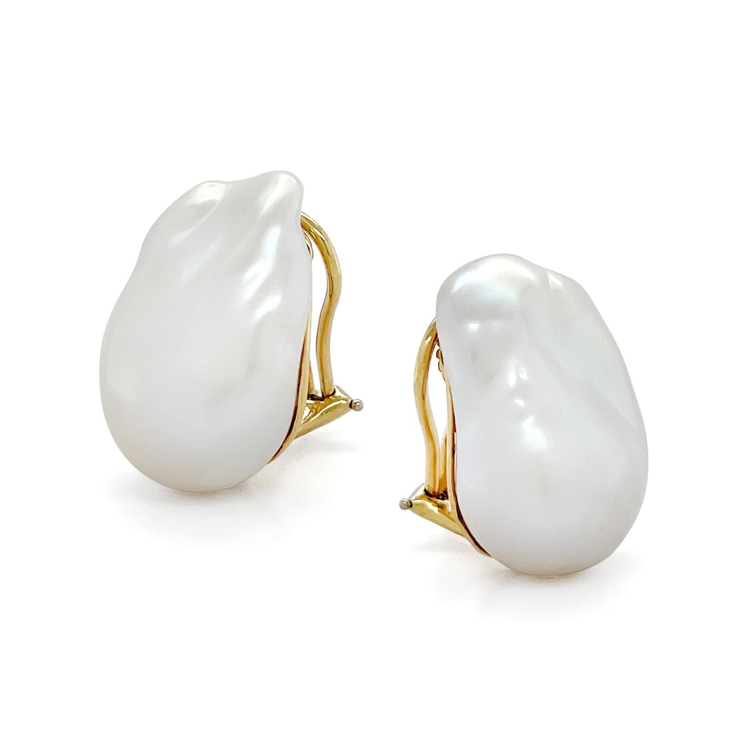 A satin sheen emits across the surface of a single freshwater baroque white pearl for these earrings. The pairing with unique shapes showcases the distinct essence that serves as the signature for baroque pearls. 18k yellow gold secures the pearls