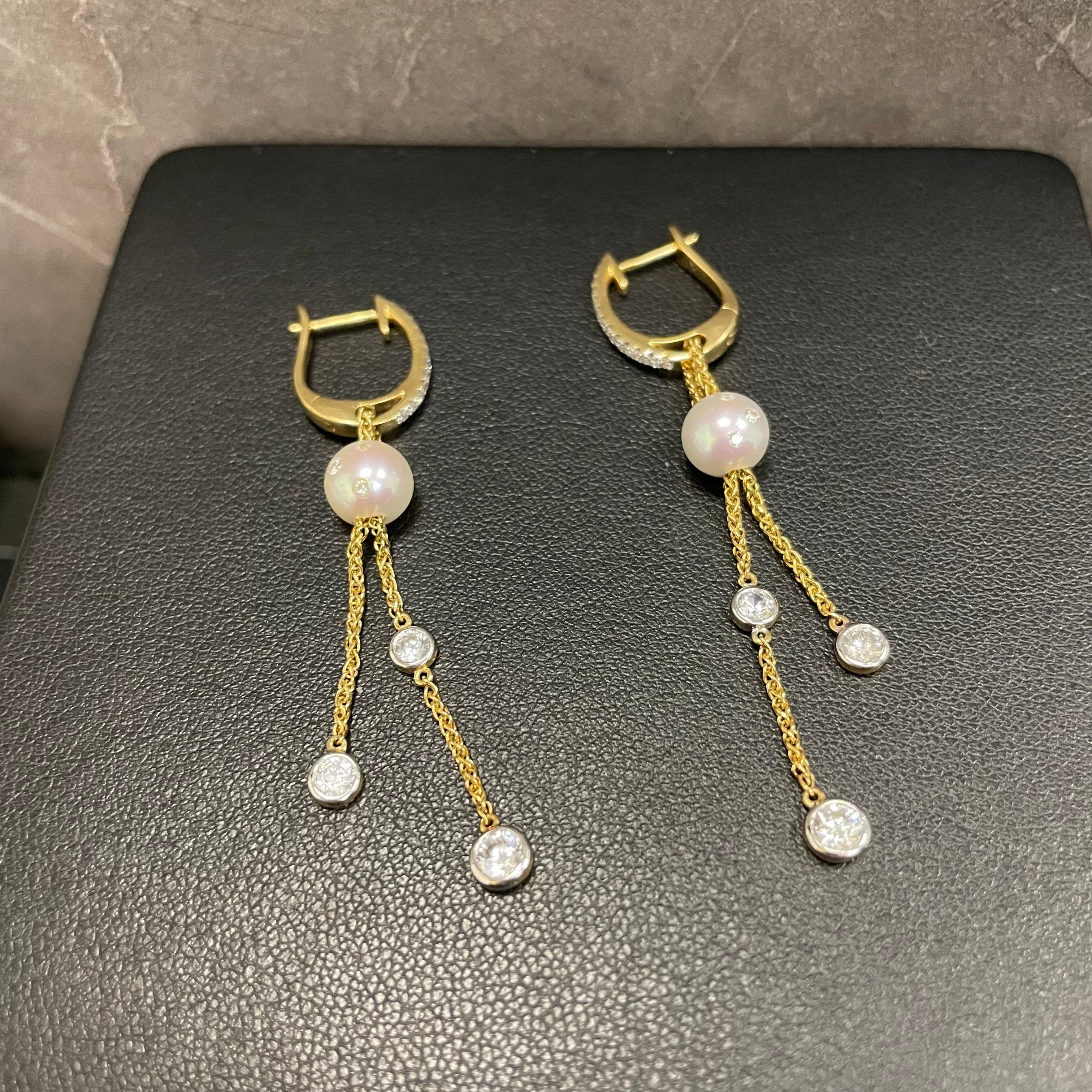 These earrings feature 15.14mm freshwater white button pearl with white sapphire set inside, suspending two diamond-set chain with different lengths, set with 18K yellow gold with diamond huggie.