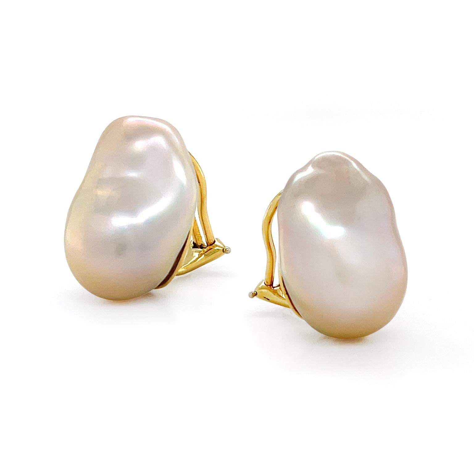 The ethereal glow of lustrous freshwater baroque pearls shows in these earrings. A single pearl is secured in 18k yellow gold, differing slightly in shape from the other. The pair features a subtle pink overtone and a silky texture that freshwater