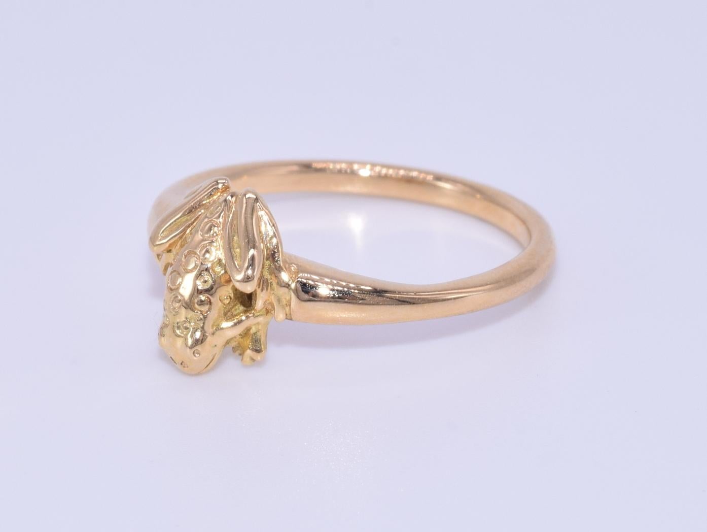 A petite frog is formed in 18 karat yellow gold, ring size 4.25.