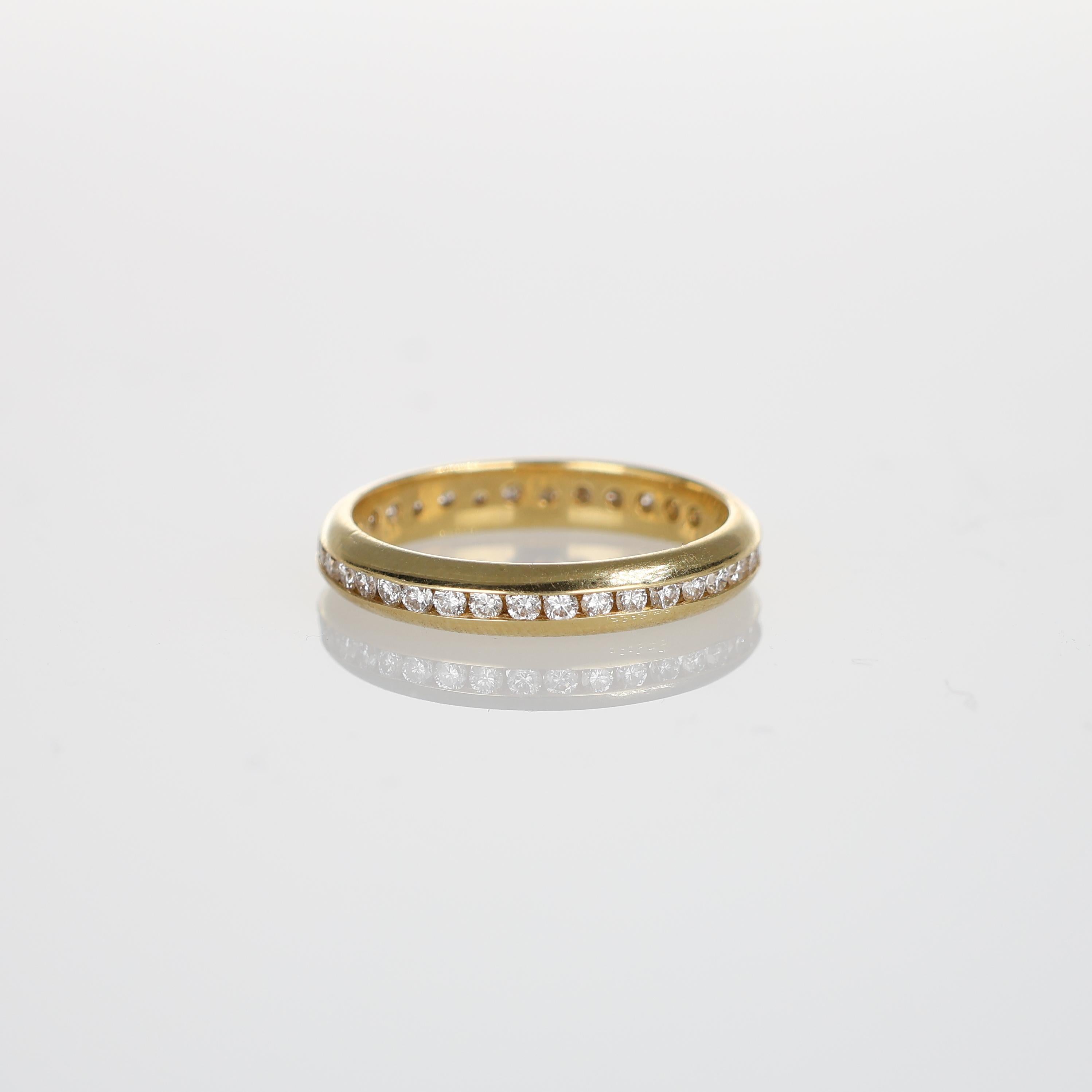 A refined full eternity band crafted in 18K yellow gold, featuring a continuous row of natural white diamonds totaling 0.50 carats. Designed with a channel setting, this ring offers a sleek and timeless elegance, perfect for stacking or wearing
