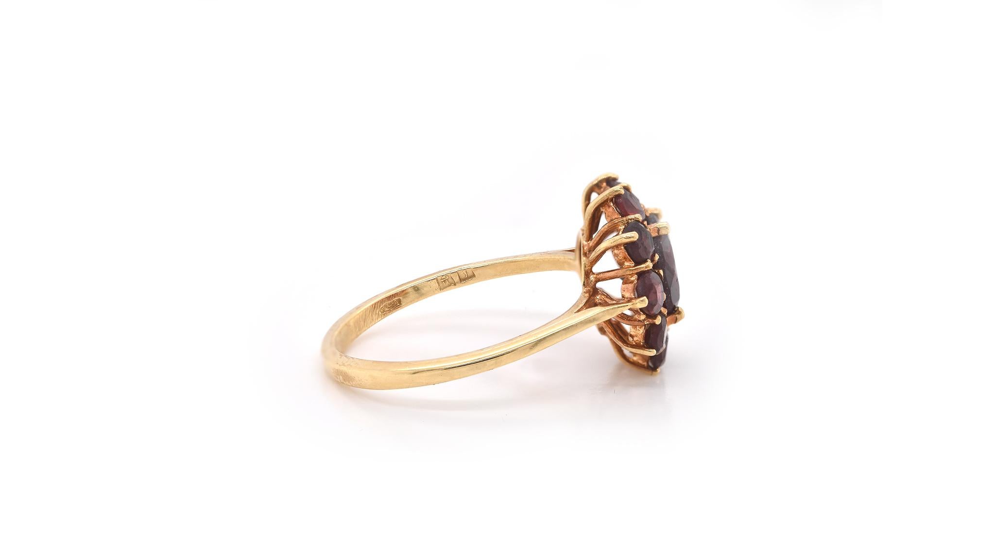 Designer: Custom
Material: 18k yellow gold
Garnets: 11 round cut garnets
Dimensions: ring top measures 13.35mm in diameter
Ring Size: 6.5 (please allow two extra shipping days for sizing requests) 
Weight: 3.5 grams
