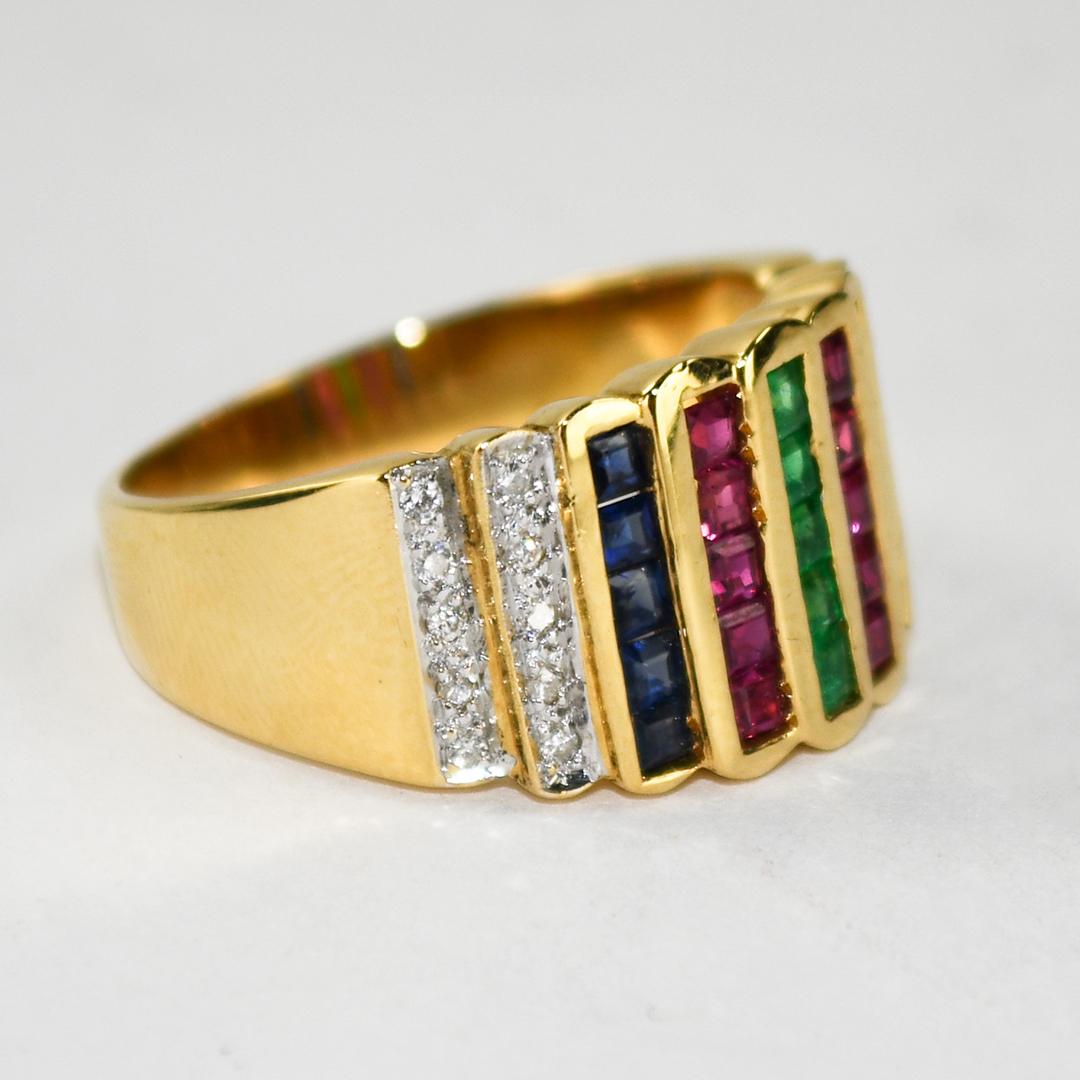 18k yellow gold and gemstone cocktail ring.
Stamped 750 and weighs 6.4 grams.
The gemstones are emerald cuts.
There are five rows of natural blue sapphires, rubies, and emeralds,  very good color, .75 total carats.
On the sides are round brilliant