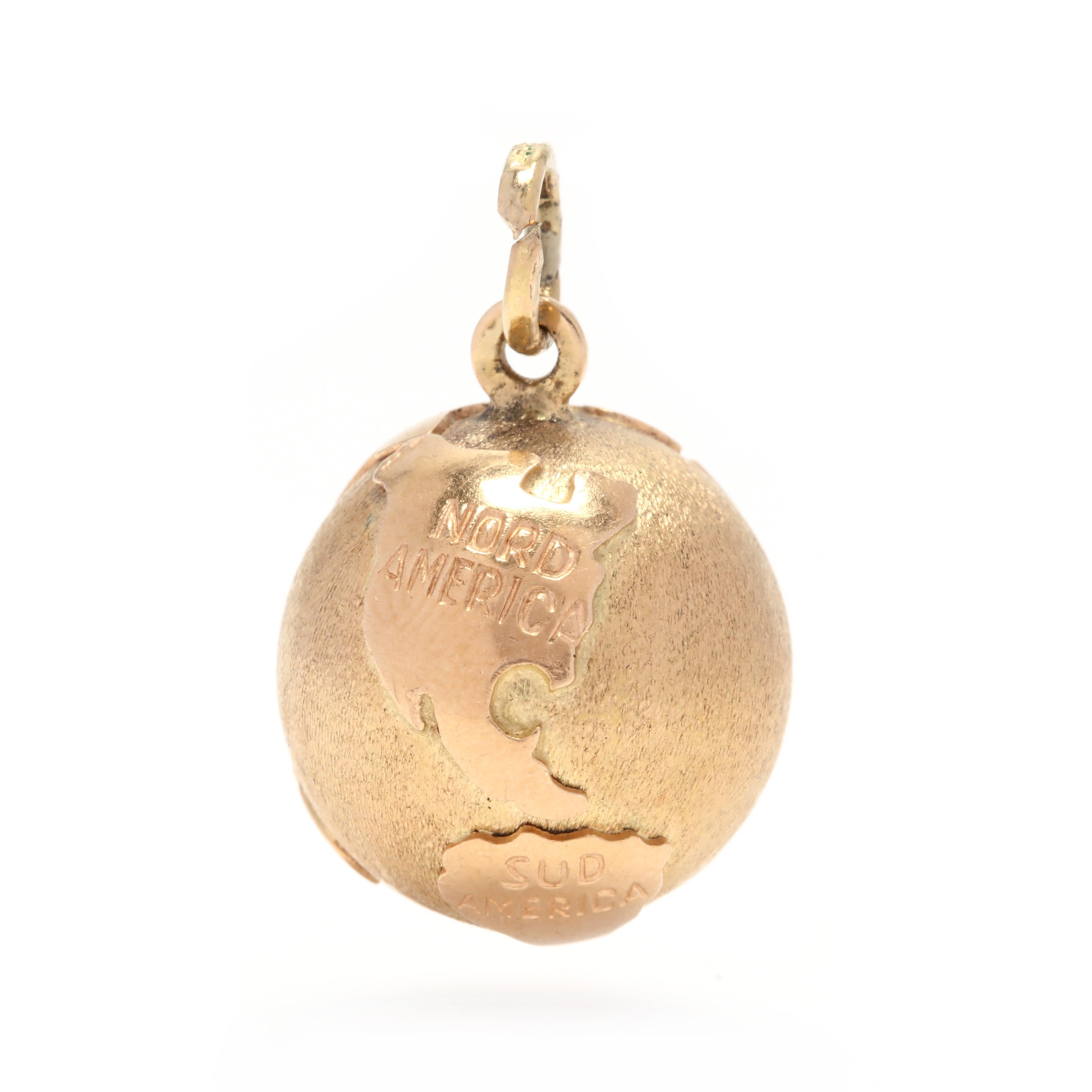 An 18 karat yellow gold globe charm / pendant. This charm features a ball shape with applied continent shaped features with engraving stating 