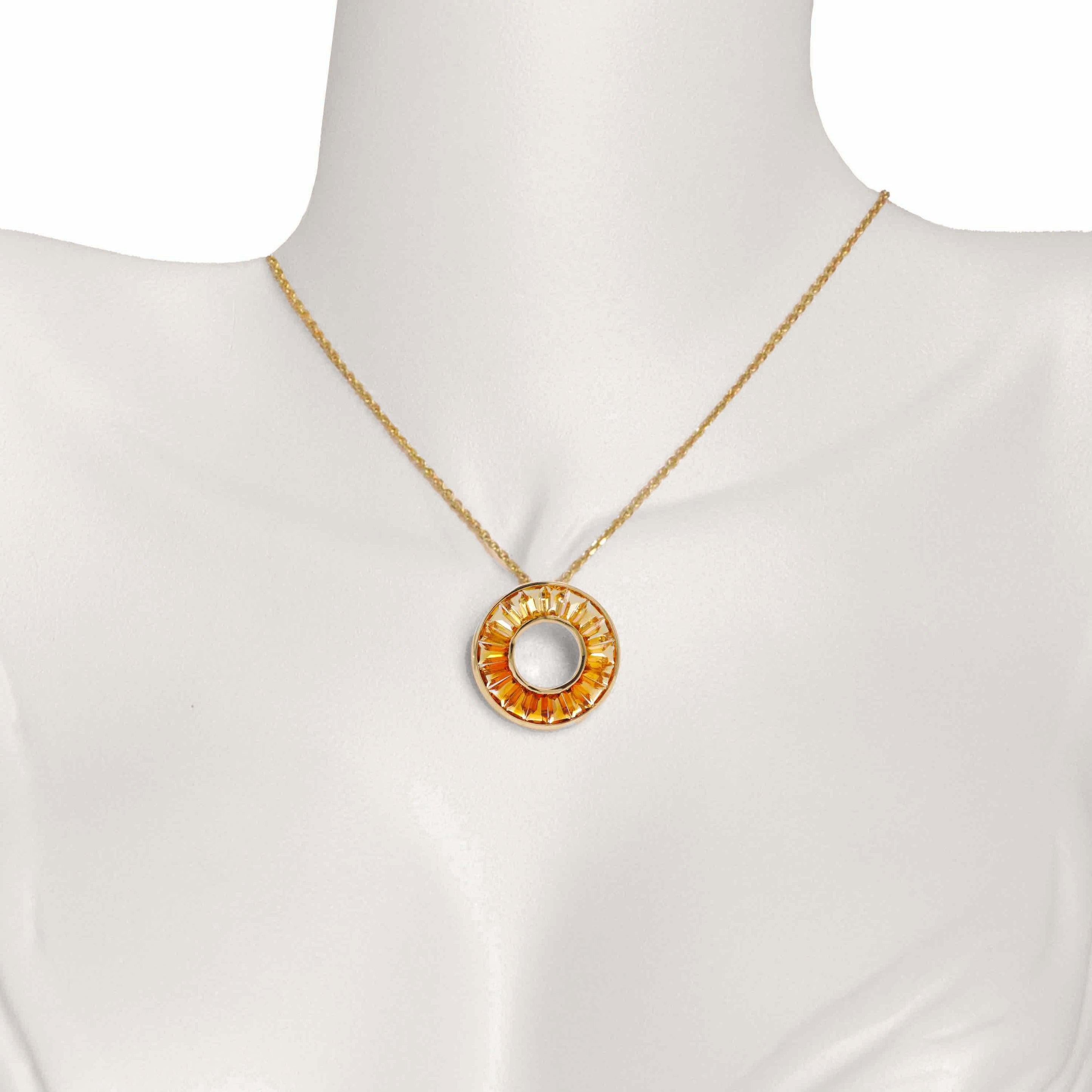 This elegant 18k yellow gold citrine circle pendant necklace is a stunning piece that radiates warmth and sophistication. This necklace features a captivating citrine gemstone in a circular setting, creating a harmonious blend of elegance and