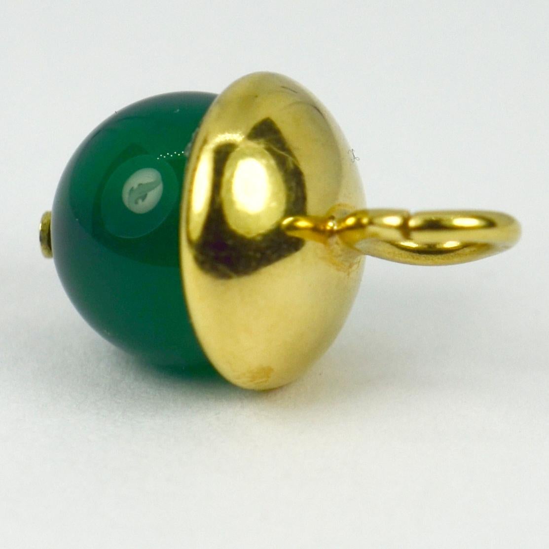 An 18 karat (18K) yellow gold and dyed green agate charm pendant designed as a sphere with gold cap. Stamped with the owl punch mark for 18 karat gold and French import.

Dimensions: 2 x 1.2 x 1.2 cm
Weight: 2.59 grams
