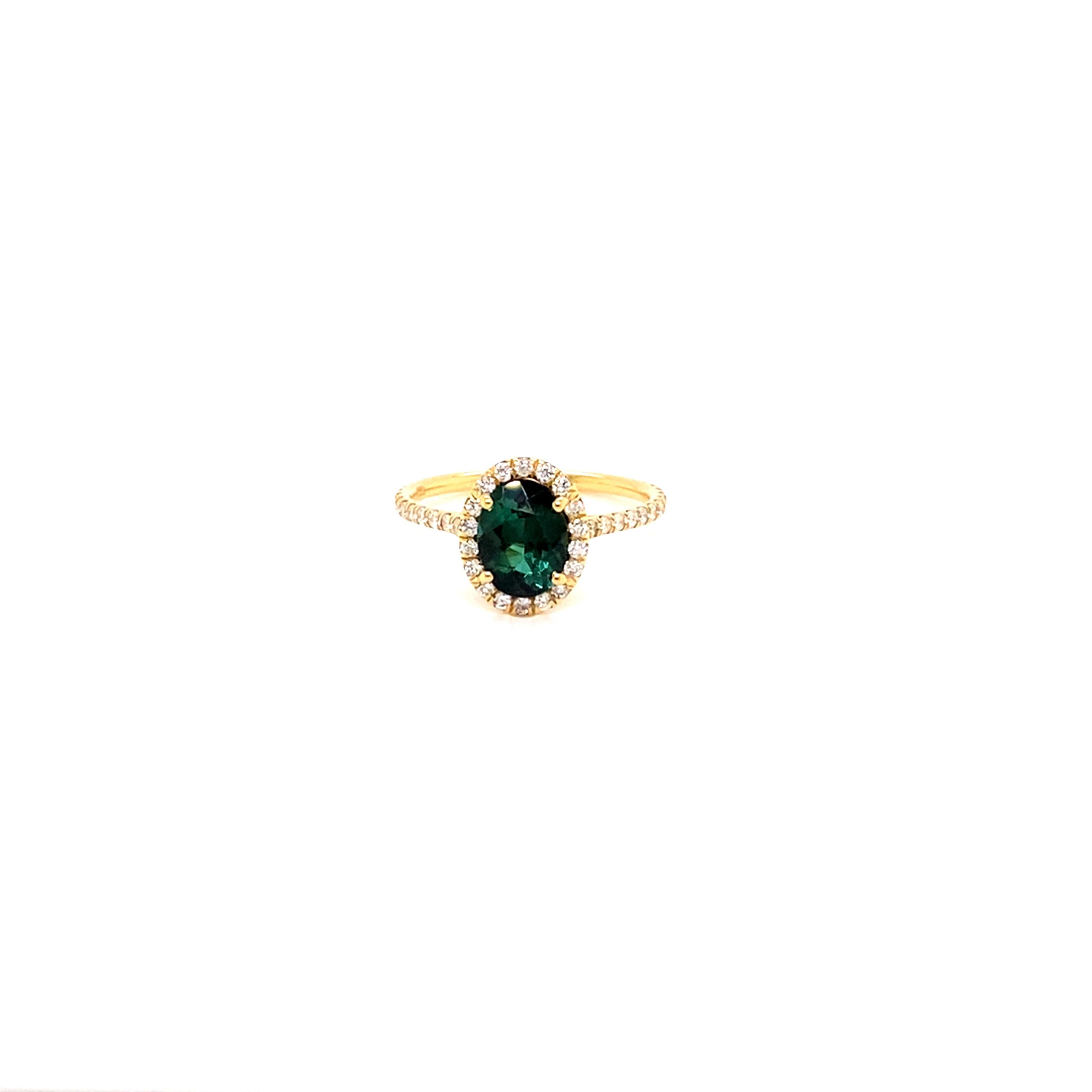 Eye Catching Oval Shaped Green Tourmaline set in a sparkling halo of diamonds in a high polish 18k Yellow Gold Ring. 

This stunning tourmaline was hand selected for its brilliance, clarity, and attractive bluish green hues. 

Handset in a delicate