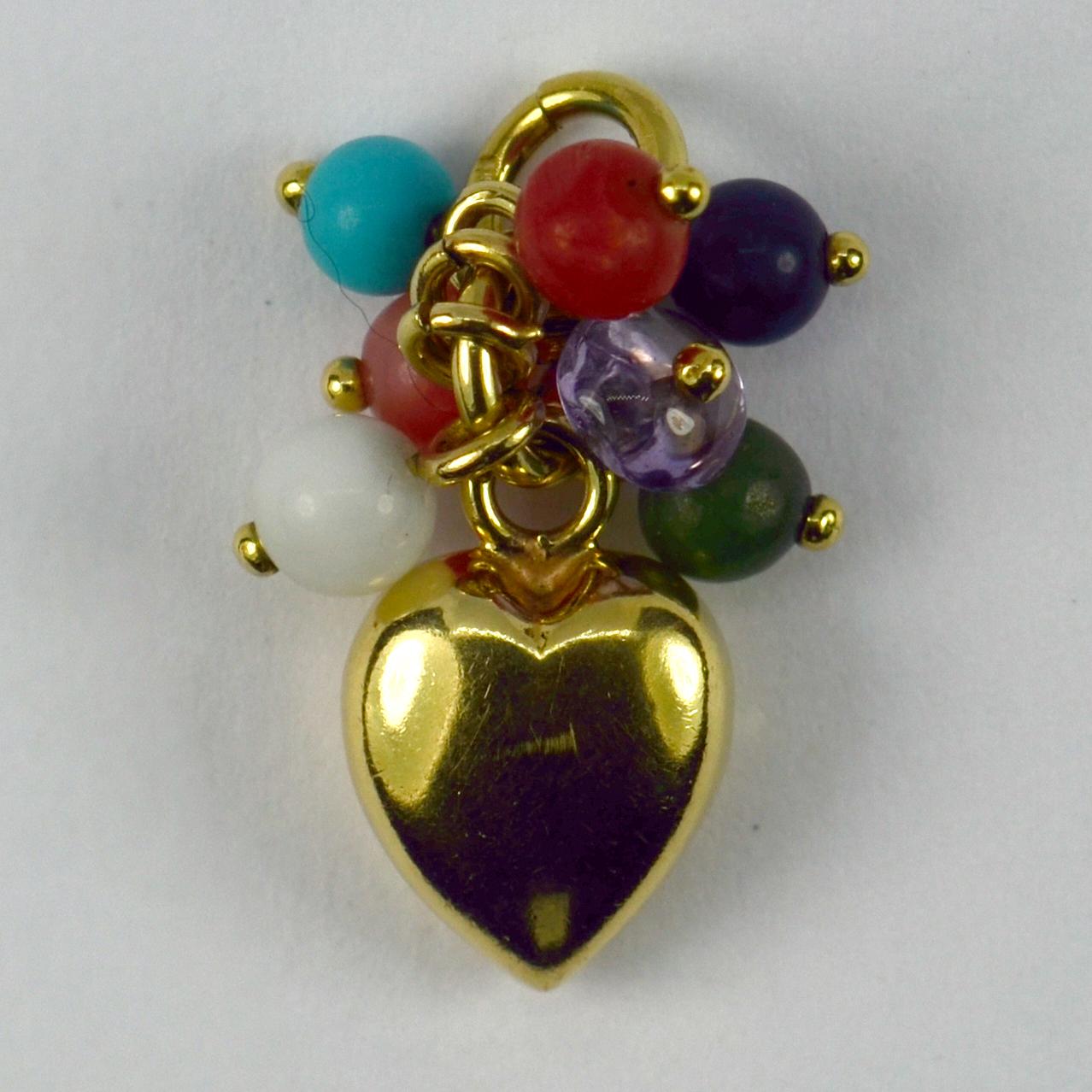 An 18 karat (18K) yellow gold and gem set charm pendant designed as a puffy heart with a gem tassel including amethyst, coral, sodalite, turquoise, nephrite and cochlong opal. Stamped with the owl punch mark for 18 karat gold and French