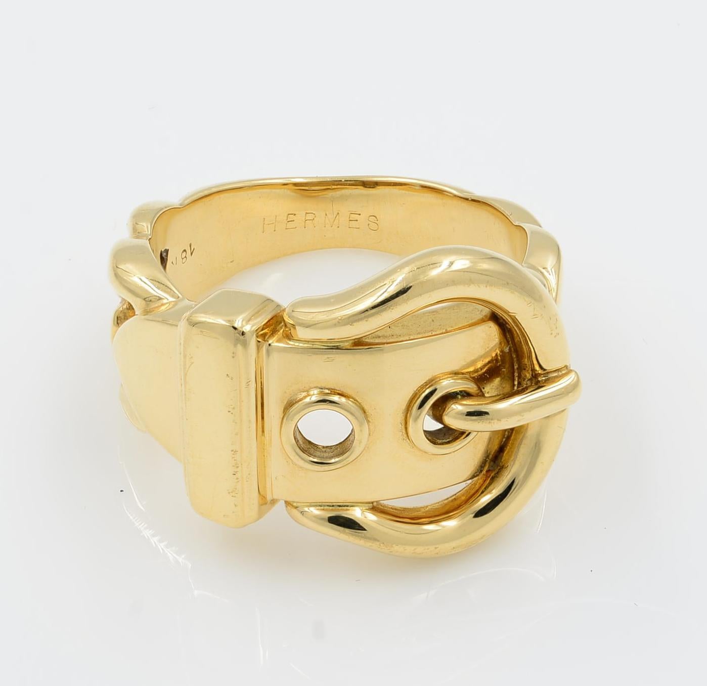 An authentic elegant ring by Hermes, this lovely ring is crafted from 18k yellow gold with a high polished finish. The front of the band features a wide belt and buckle style, tapering off at the two sides are graduated curb link design which tapers