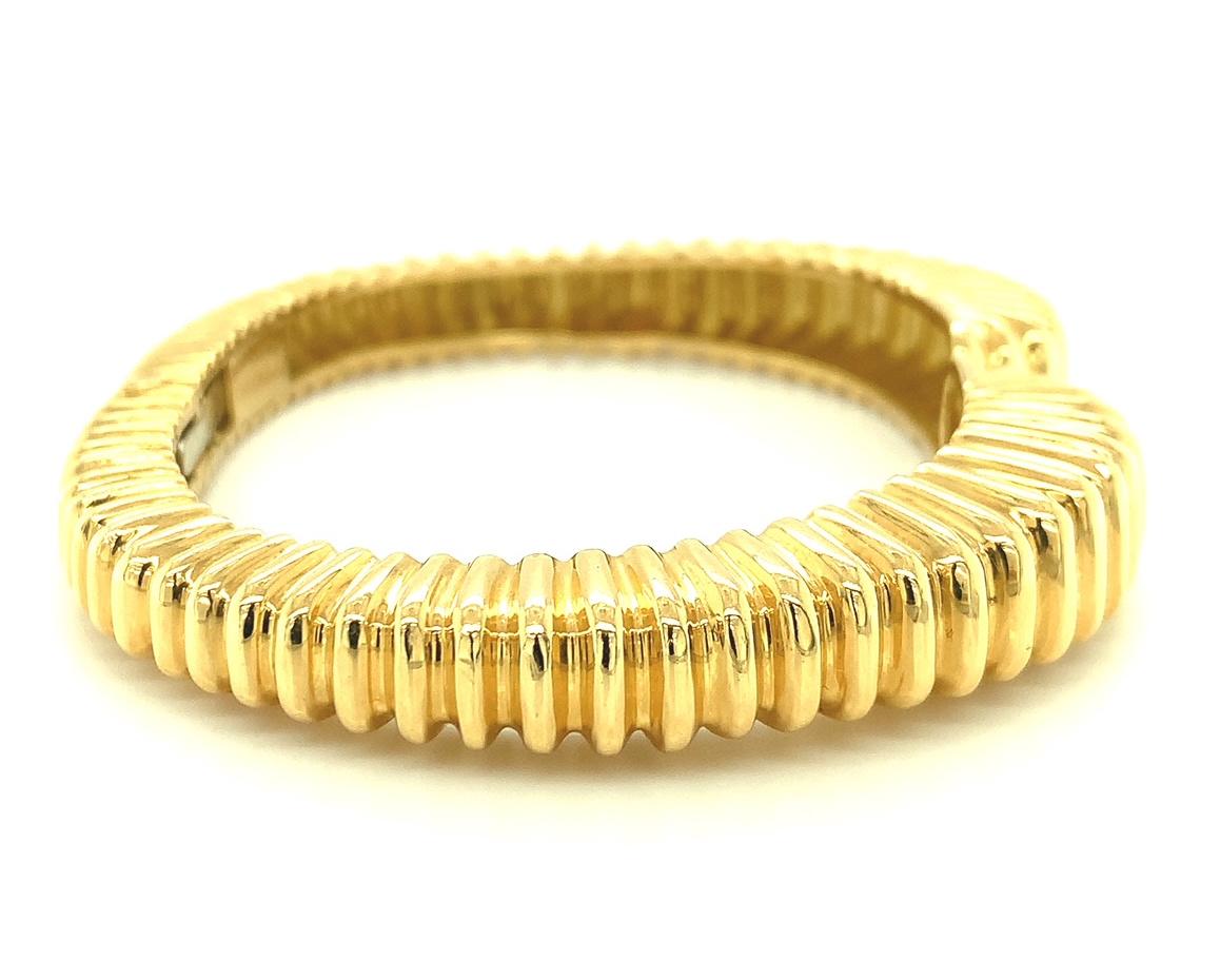 Bold gold! This beautiful bracelet is heavily constructed of 18k yellow gold weighing approximately 63 grams. It has a scalloped design that tapers in width from center front to center back. (Please refer to additional photographs of this bracelet.)