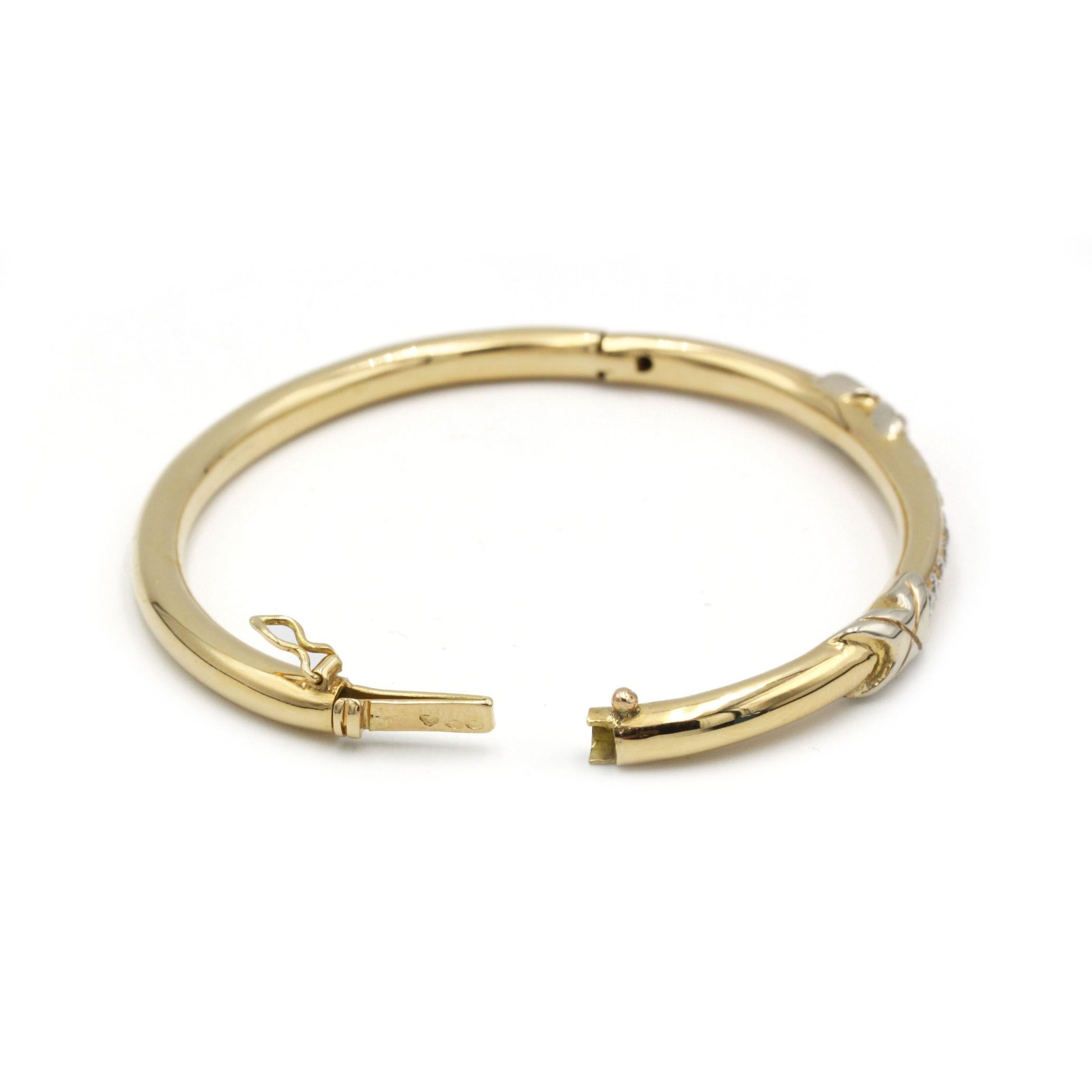 Cet exquis bracelet à charnière en or jaune 18 carats (750 ‰) marie des lignes épurées et contemporaines à une subtile touche Art déco. Une barre centrale surélevée est sertie de 10 diamants ronds de taille brillant totalisant environ 1,00 carat,