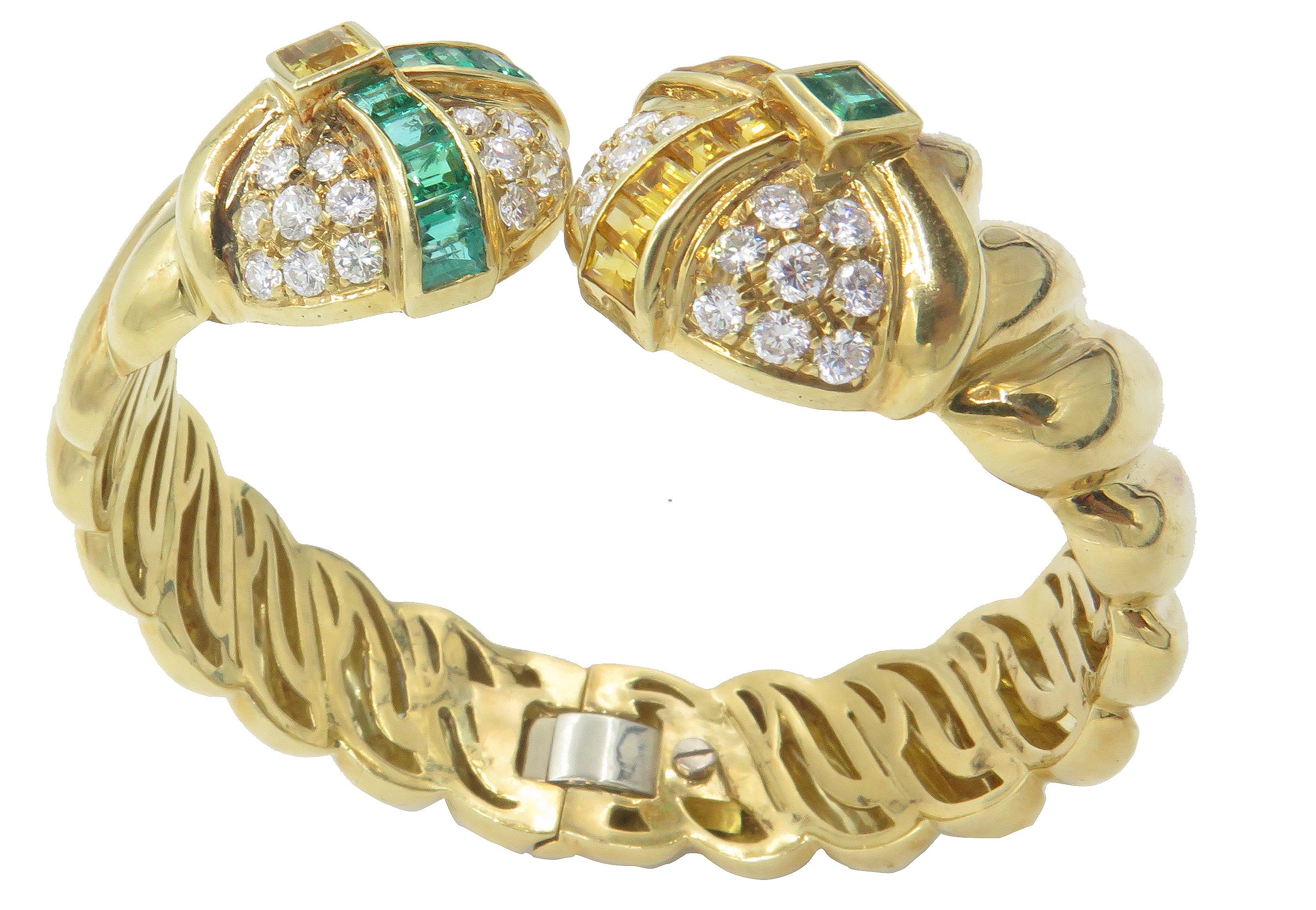 An exquisite 18K yellow gold hinged bangle with approximately 3cts of diamonds and 1.25cts of fine cut emeralds.. This charming piece features sparkling white diamonds mounted inbetween rows of channel-set emeralds and citrine. The intricately
