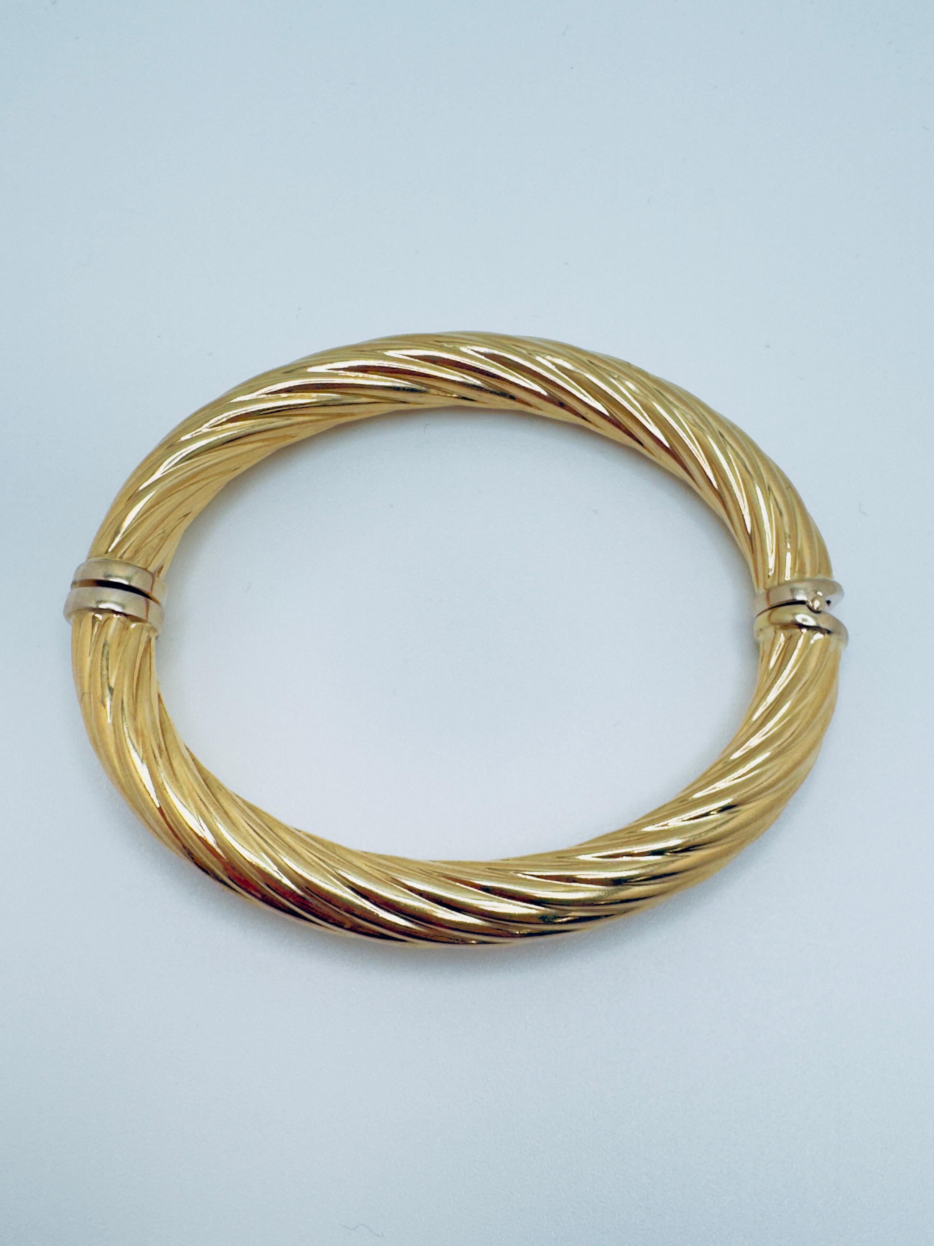 Esta exquisita pulsera brazalete está elaborada en lujoso oro amarillo de 18 quilates, combinando elegancia con una sensación sustancial pero cómoda. Con un peso de 16,7 gramos, ofrece una presencia notable en la muñeca a la vez que mantiene la