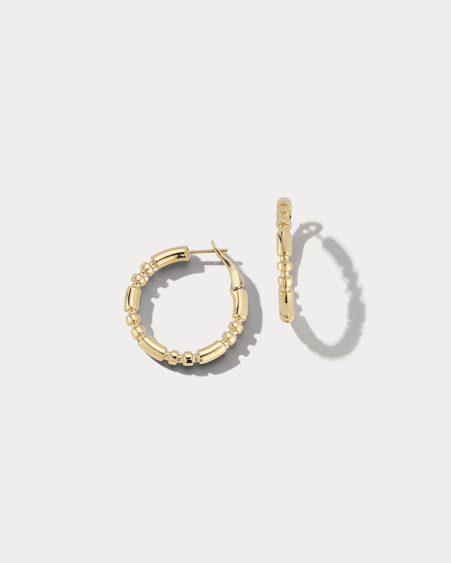 These exquisite hoop earrings are made from premium 18k yellow gold and feature a sleek, polished finish. The small size of the hoops makes them ideal for everyday wear or for adding a touch of luxury to a special occasion. The hoops have a classic