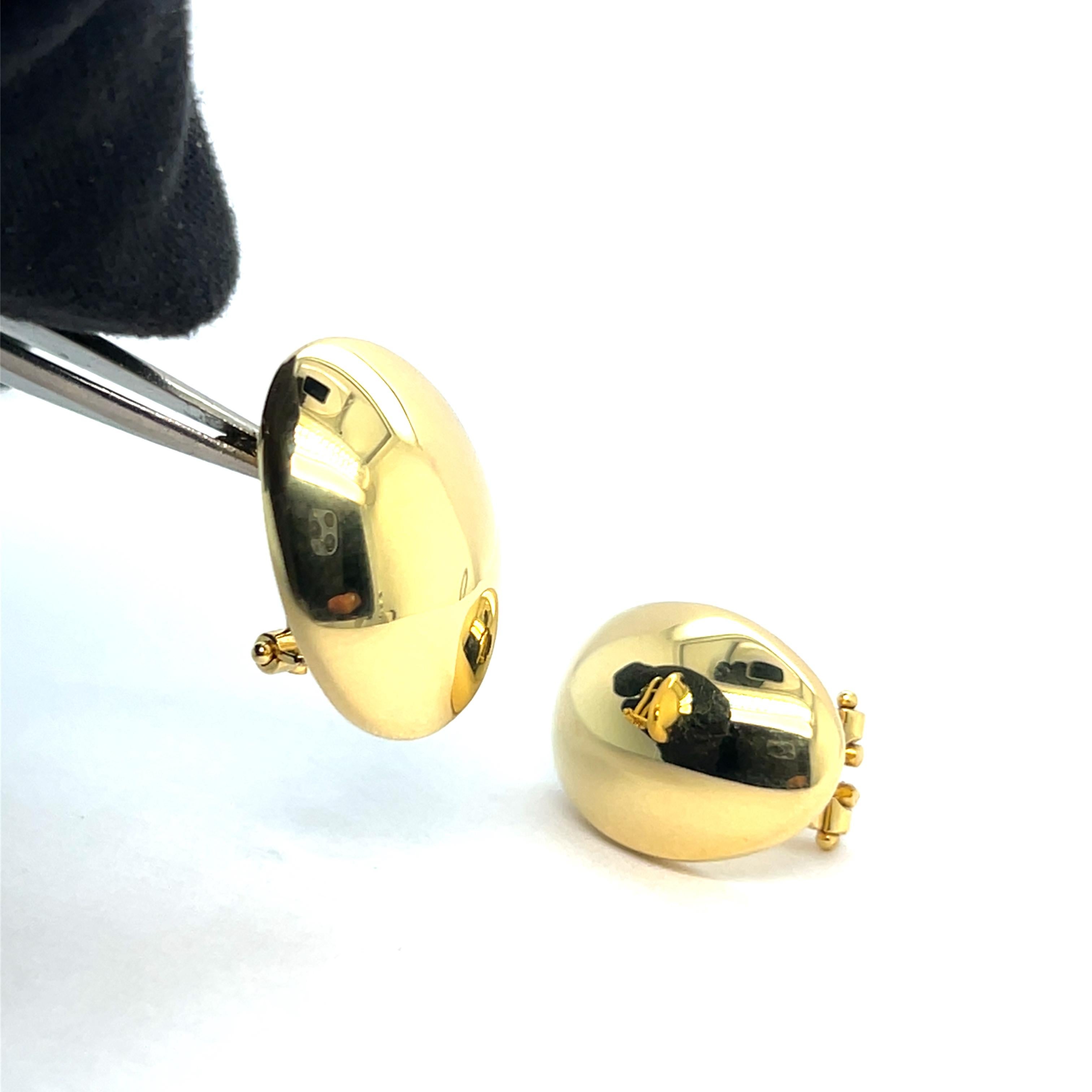 Questi orecchini a cerchio in oro giallo 18 carati di Mesure et art du temps incarnano la massima eleganza italiana. La loro silhouette delicatamente arrotondata, impreziosita da charms penzolanti che si muovono delicatamente, crea un raffinato