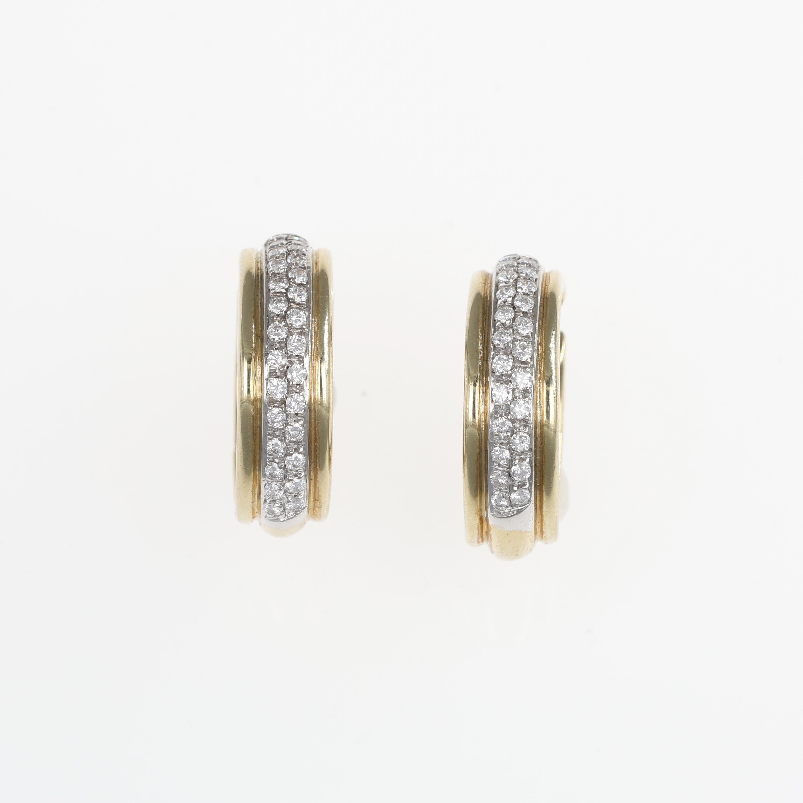 A timeless pair of hoop earrings crafted in 18K yellow gold, featuring a central row of brilliant-cut diamonds totaling 0.86 carats. The sleek design and shimmering diamonds make these earrings a versatile accessory, perfect for adding a touch of