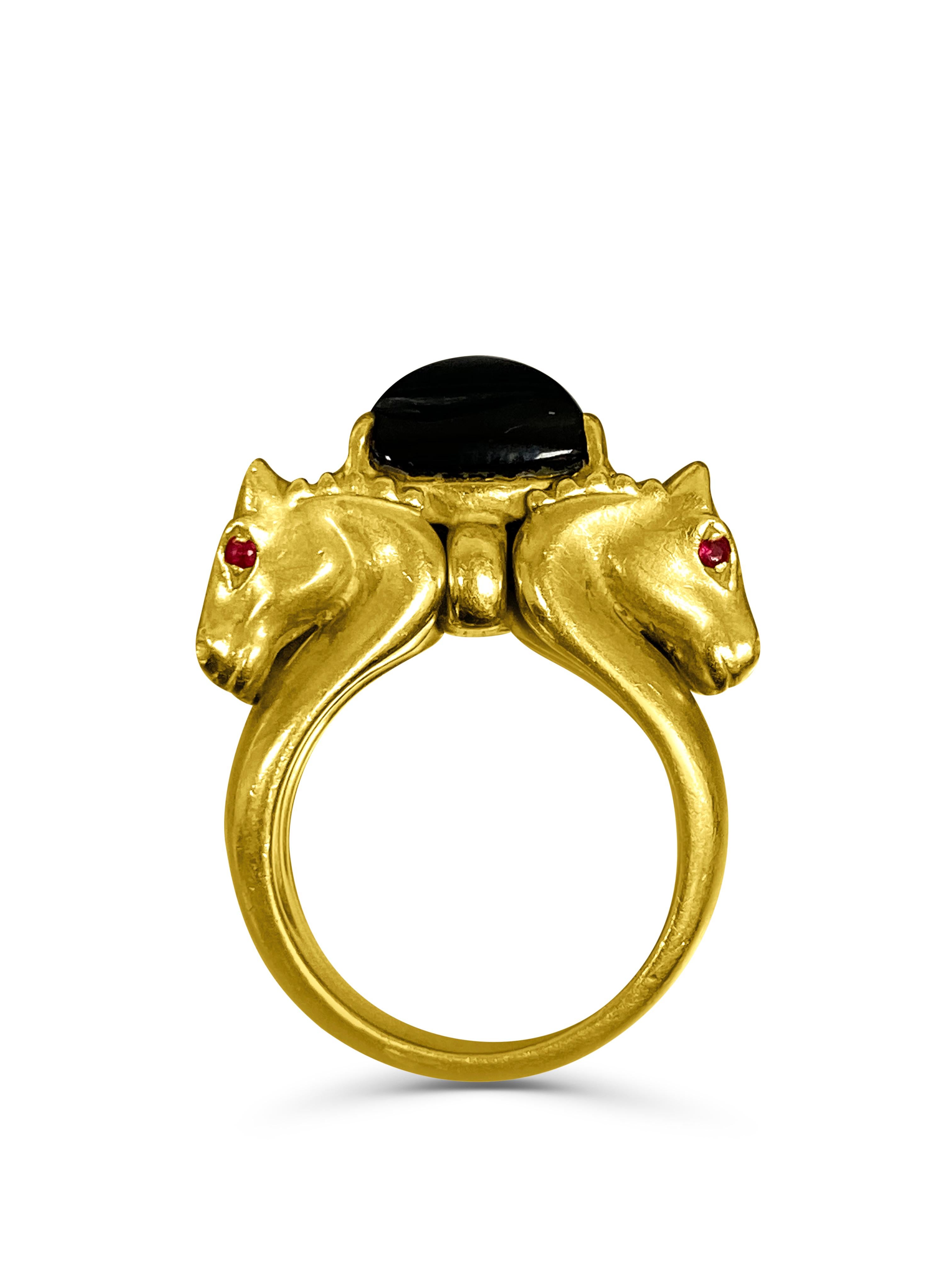 18 karat yellow gold horse ring, centering a trillion cut black Onyx (6.55 carats). Each horse eye is set with natural rubies, totaling 8 rubies. 

✔ Natural Black Onyx and Ruby's
✔ Gold Karat: 18K 
✔ Gemstone: Black Onyx 
✔ Onyx Shape: Trillion
✔ 8