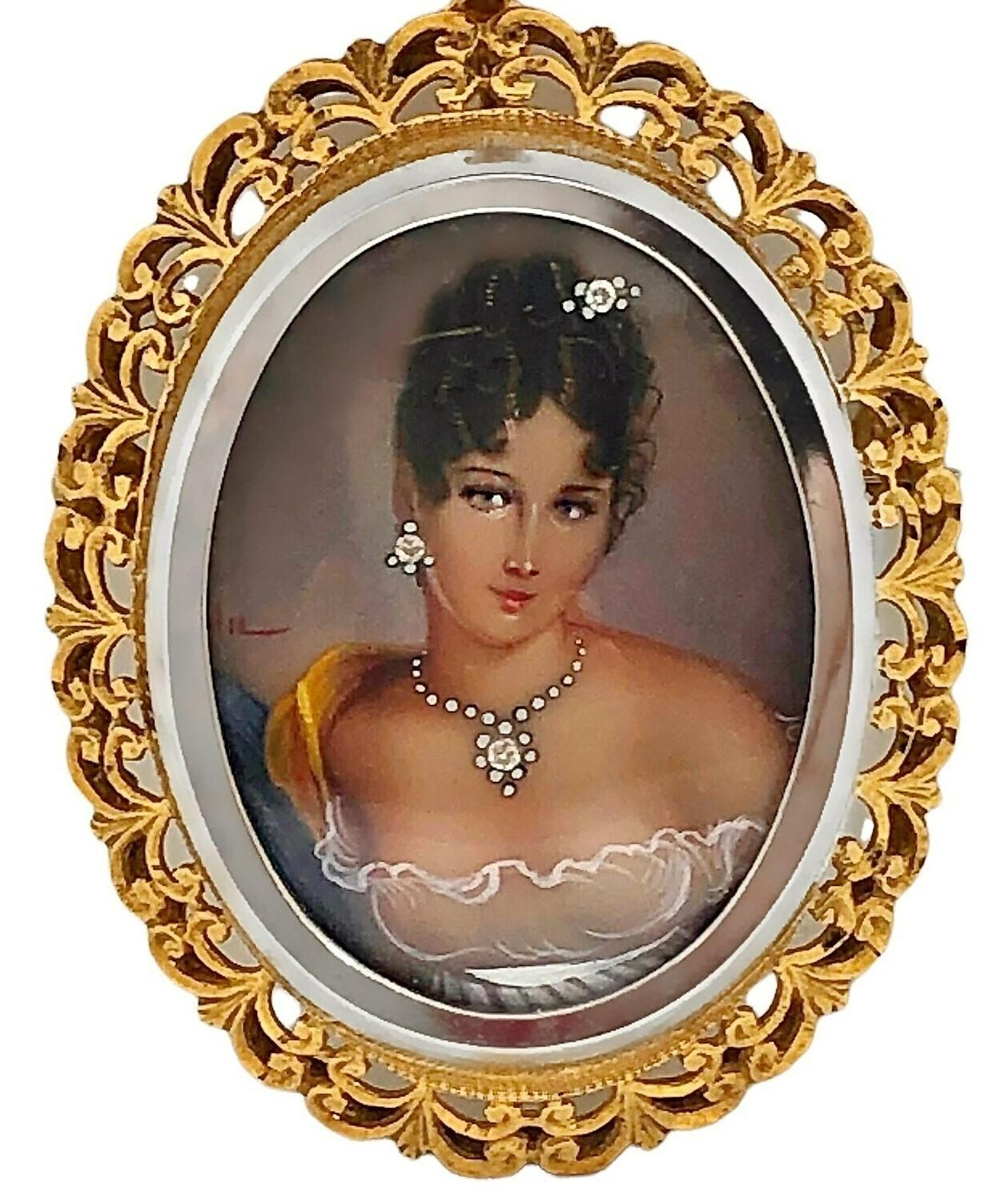 This lovely 18K yellow gold and hand painted portrait piece is replete with extraordinary details. The crystal covered portrait features an elegant lady dressed in traditional garb, accented with three diamonds. The 18K yellow gold frame is