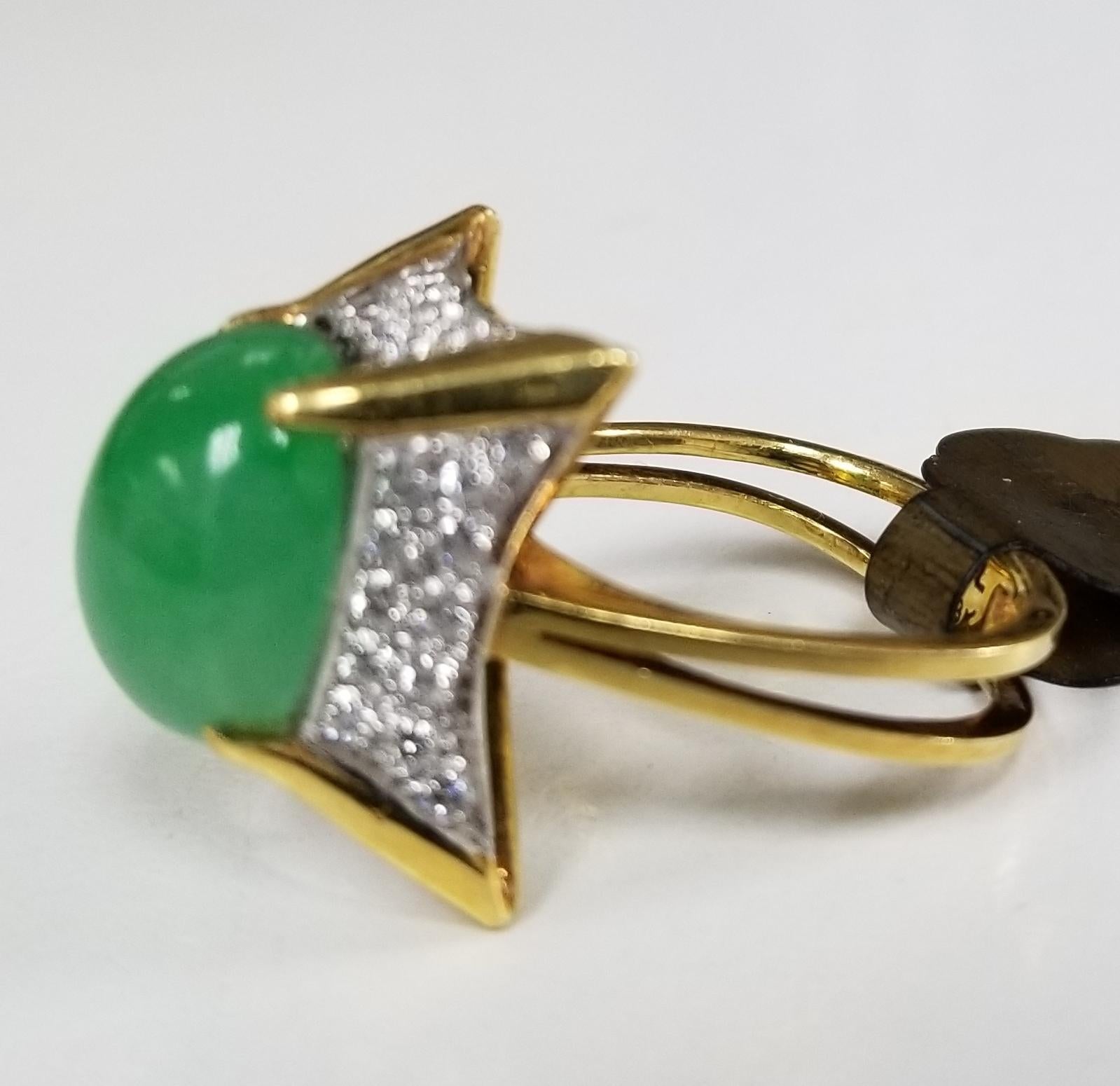 This piece of fine jewelry was designed and hand crafted by “Moshi” of New York, it was found in a vault from an estate sale and was never used.  18k yellow gold jade and diamond ring, containing 1 oval cabochon jade 13 x 9.5 mm and 40 round full