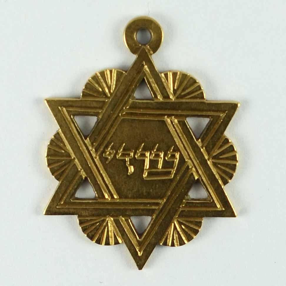 A French 18 karat (18K) yellow gold charm pendant designed as the Jewish Star of David engraved with the Yiddish phrase for ‘Shaddai’, meaning ‘Almighty’. Stamped with 750 for 18 karat gold to the reverse.

Dimensions: 2.8 x 2.1 x 0.1 cm
Weight: