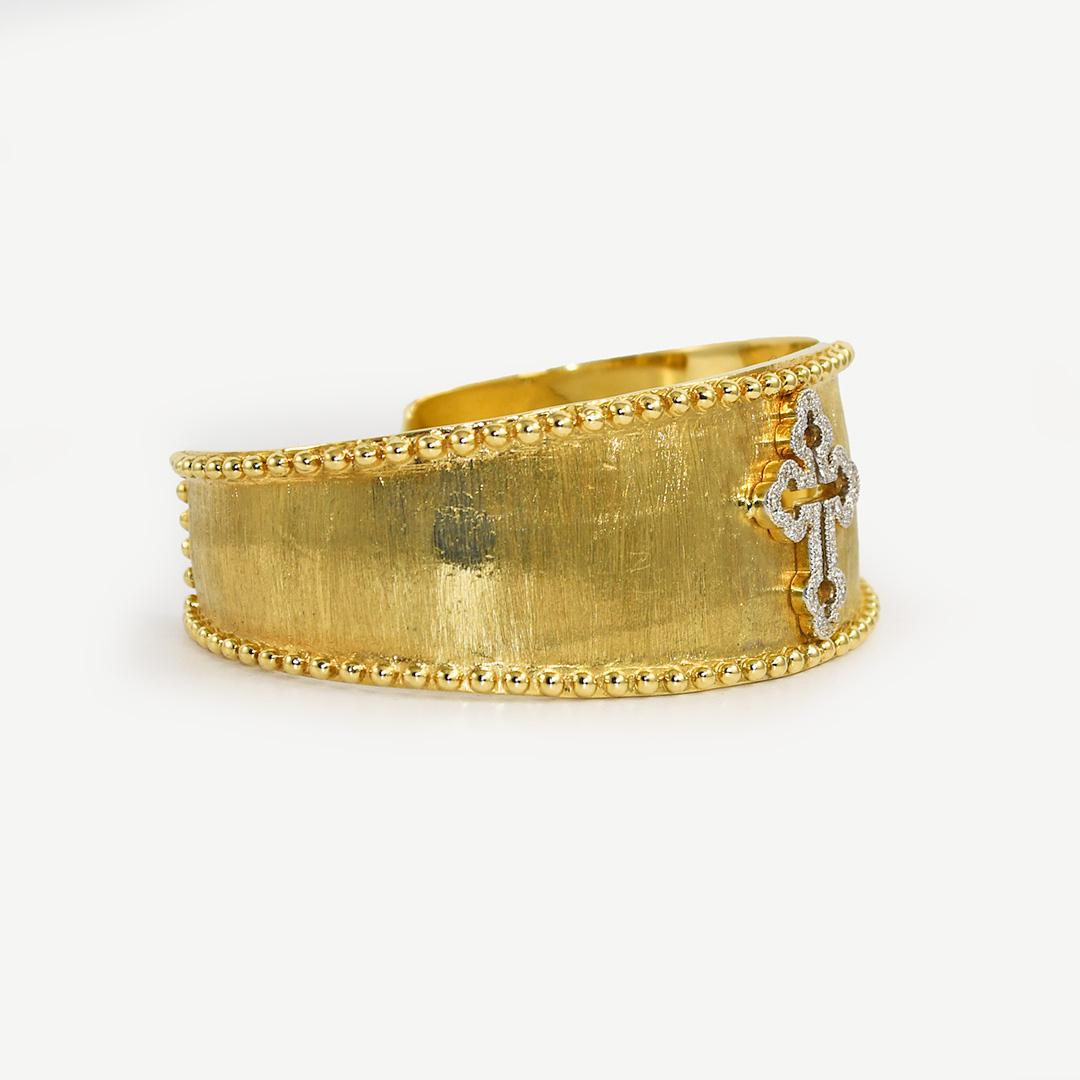 Jude Francis designer cuff bracelet in 18k yellow gold.
Stamped Jf 750 and weighs 60 grams.
The diamonds in the cross design are round brilliant cuts, .28 total carats, G to H color, Vs clarity.
The bracelet has a brushed finish and measures 24mm