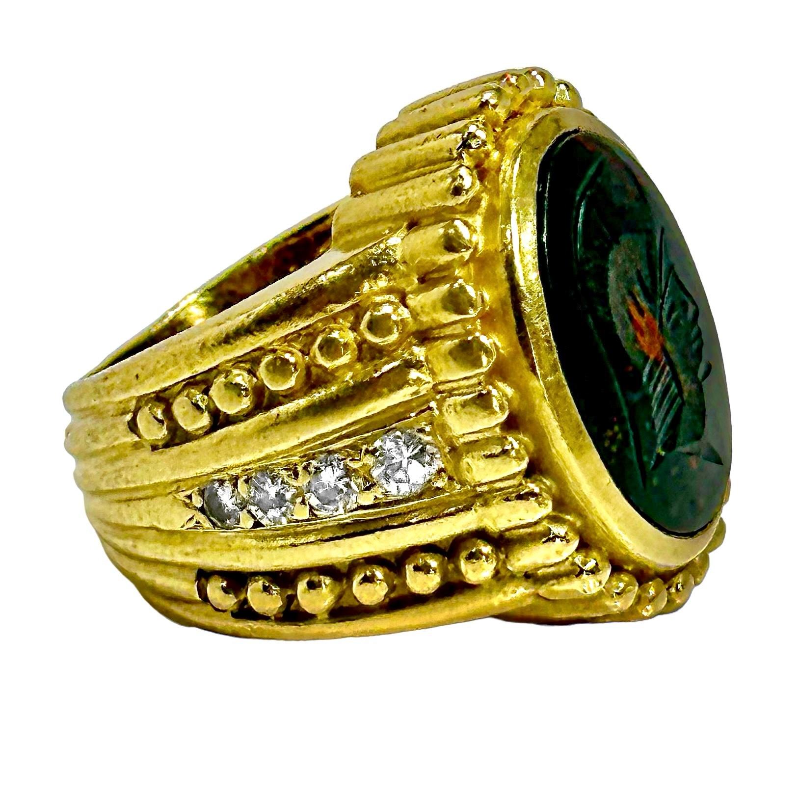 This 18K yellow gold Signet Ring by Judith Ripka is centered around an oval shaped soldier's profile intaglio in bloodstone measuring 16mm X 12mm. Deriving its styling cues from ancient design, it features classical beadwork and fluting. The