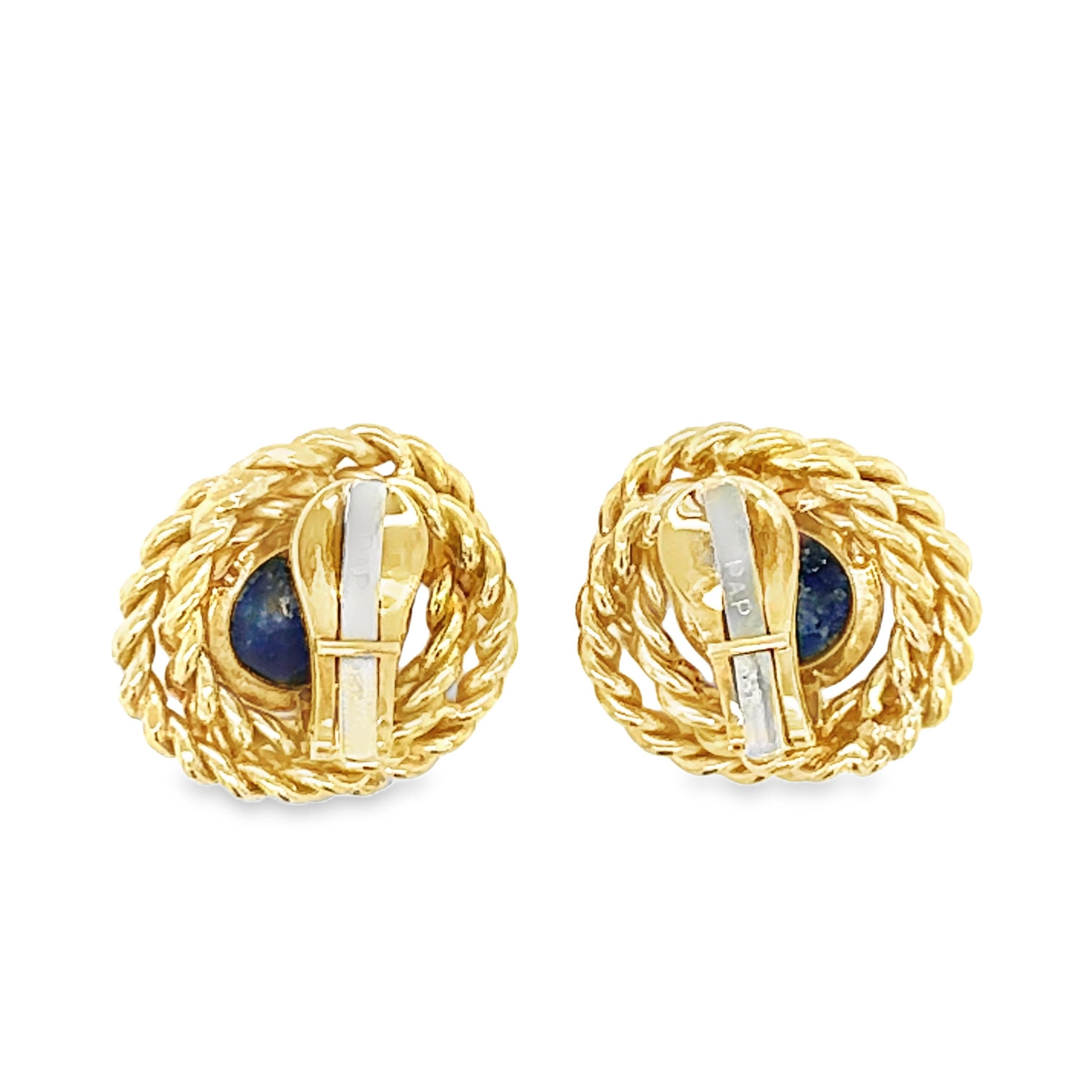 These elegant 18K yellow gold earrings feature a striking oval cabochon lapis lazuli at the center, surrounded by a detailed gold rope design that enhances their vintage appeal. The lapis lazuli, measuring 11 millimeters in diameter, showcases its