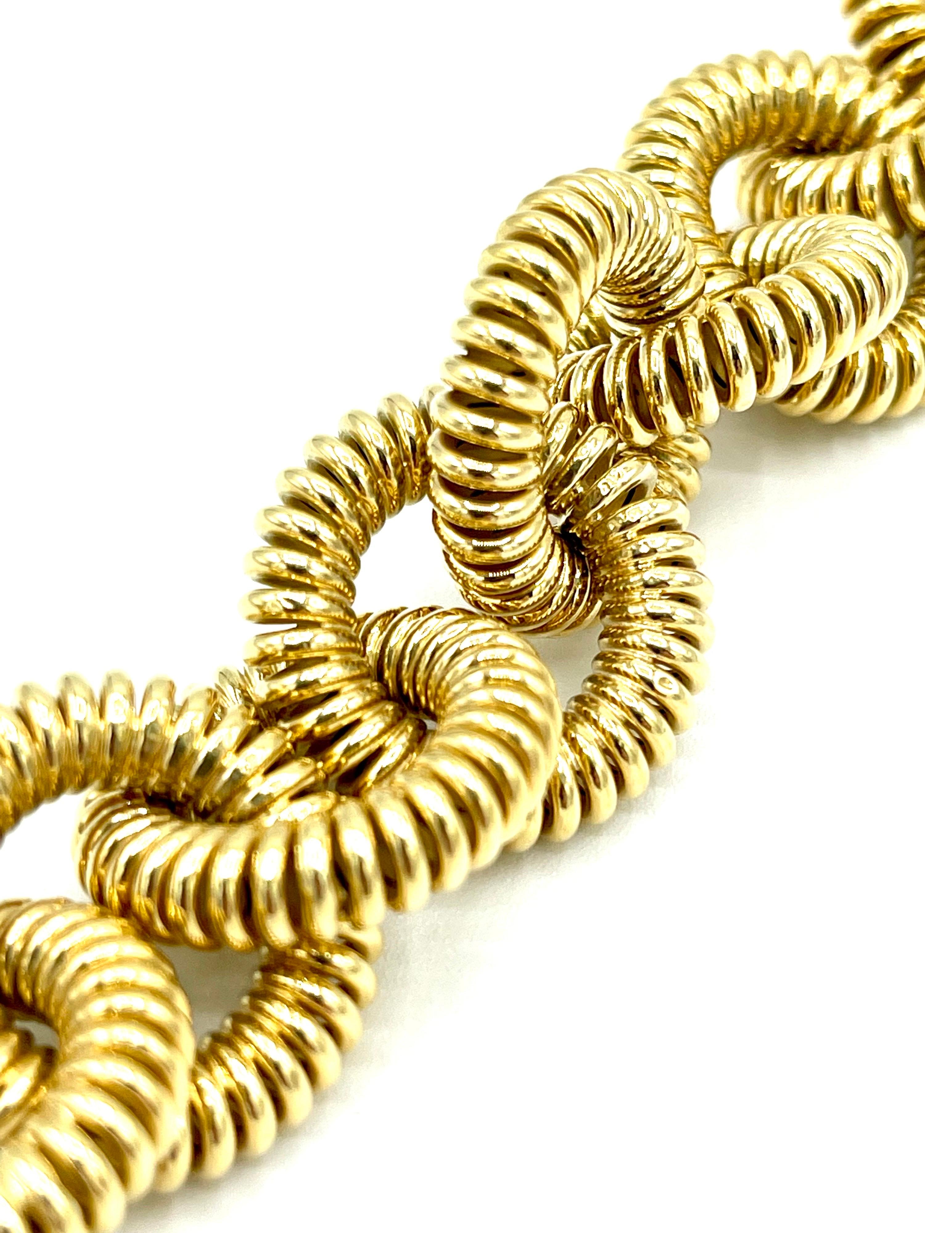 A beautiful polished 18K yellow gold bracelet.  The 1.00 inch circular links are designed in a spiral pattern, giving this bracelet a very unique look.  This bracelet features a very easy to use spring loaded clasp that simply connects to the last