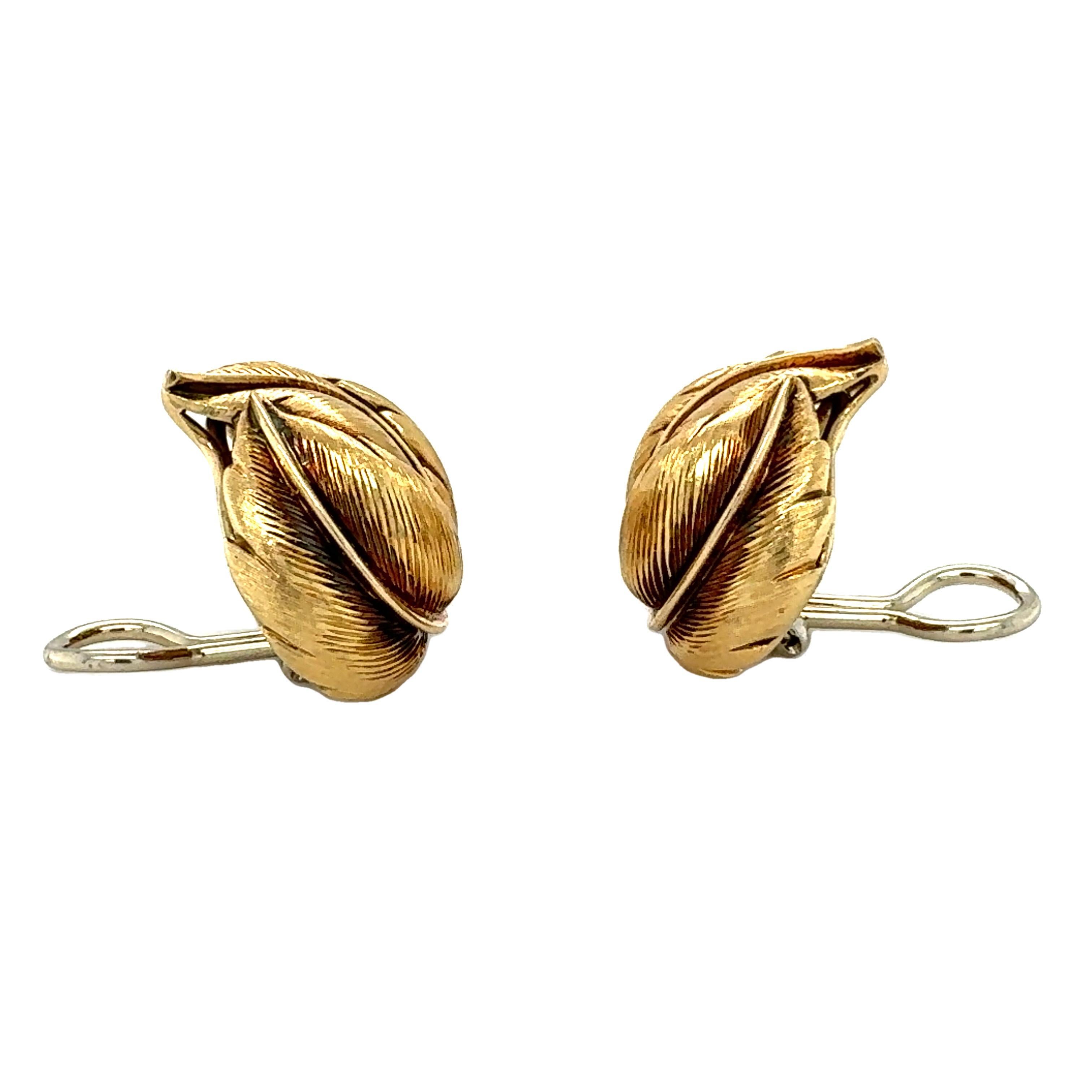 These exquisite 18K yellow gold earclips capture the natural beauty of hand-textured craftsmanship with an intricate leaf motif that embodies the elegance of the 1960s. Measuring 26 mm wide, each earclip features a richly detailed, textured finish