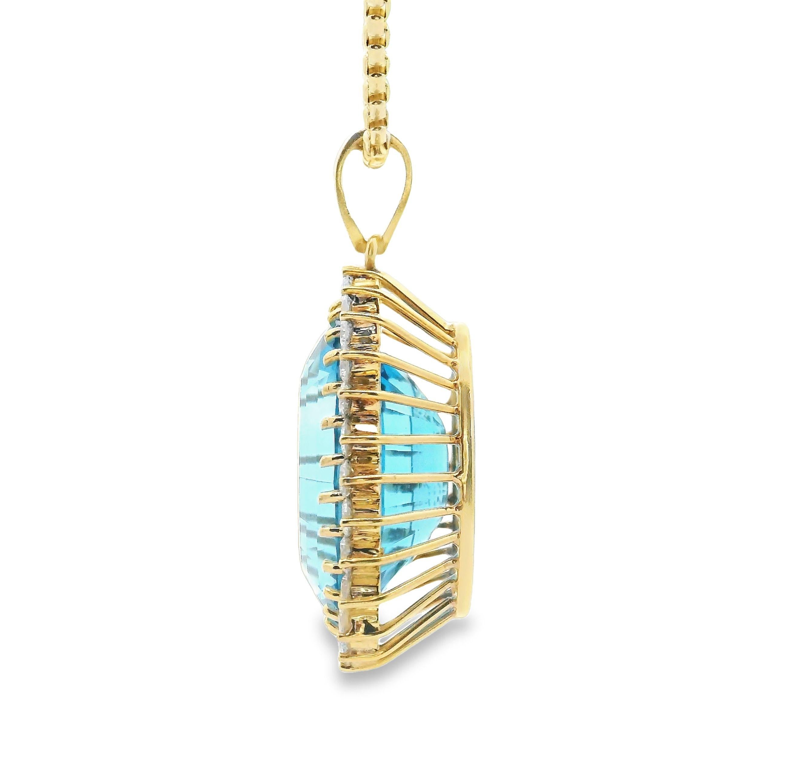 Preowned 18K yellow gold pendant featuring one oval shape London blue topaz measuring approximately 28mmx19.40mm.  The topaz is surrounded by 28 round brilliant-cut diamonds weighing approximately 3.00 carats total(E/F color, VS clarity). The