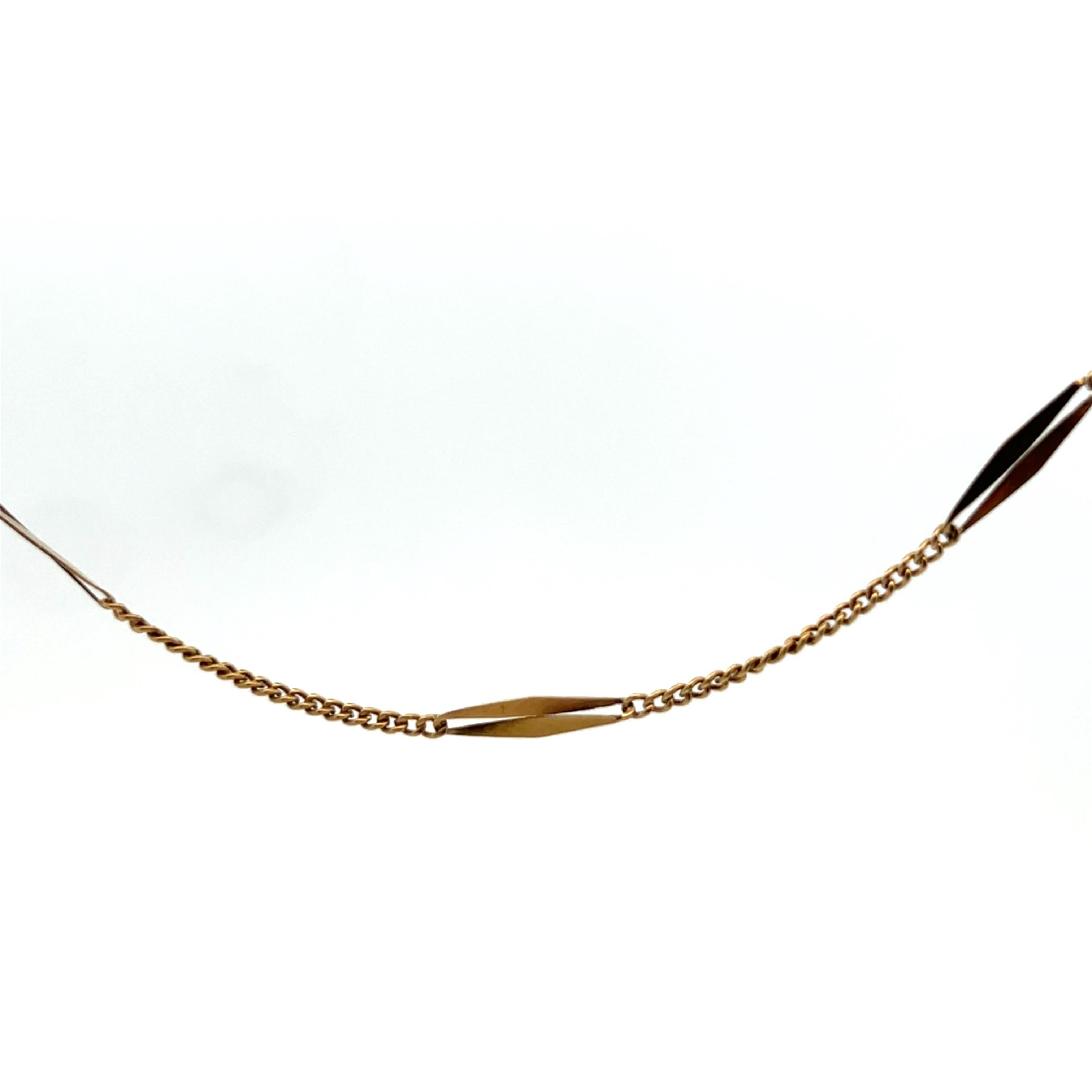 This beautiful French bar chain is made in 18k yellow gold and is 61 inches in length. The chain features alternating elongated gold bars connected by curb style links. The chains gold bars catch the light with a gentle shimmer, making it both