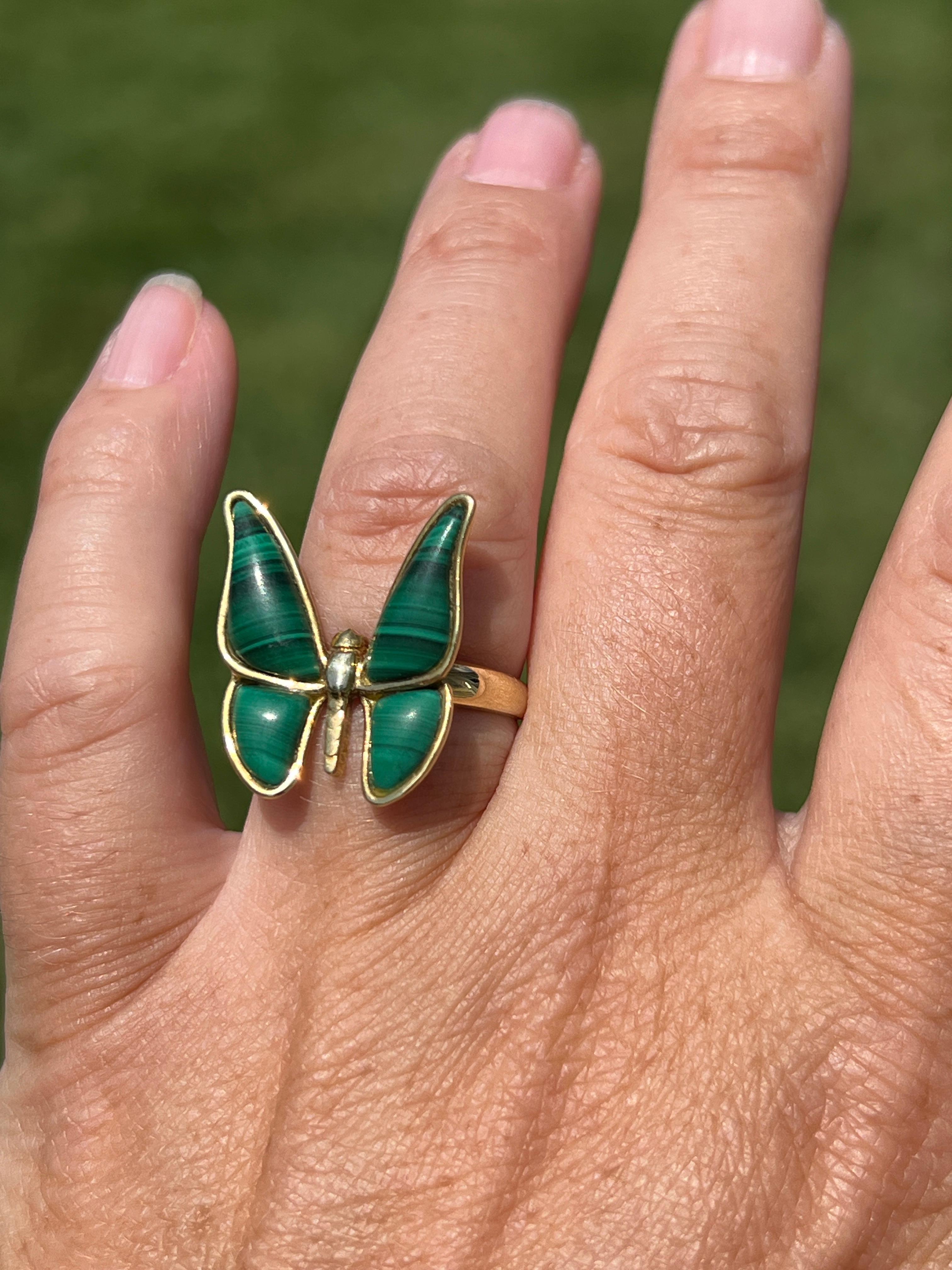 Embrace vintage charm with this exquisite 1980s butterfly ring, crafted from 18 karat yellow gold. The ring is beautifully set with four green slabs of malachite. The rich green hues of the malachite perfectly complement the warm gold tones, making