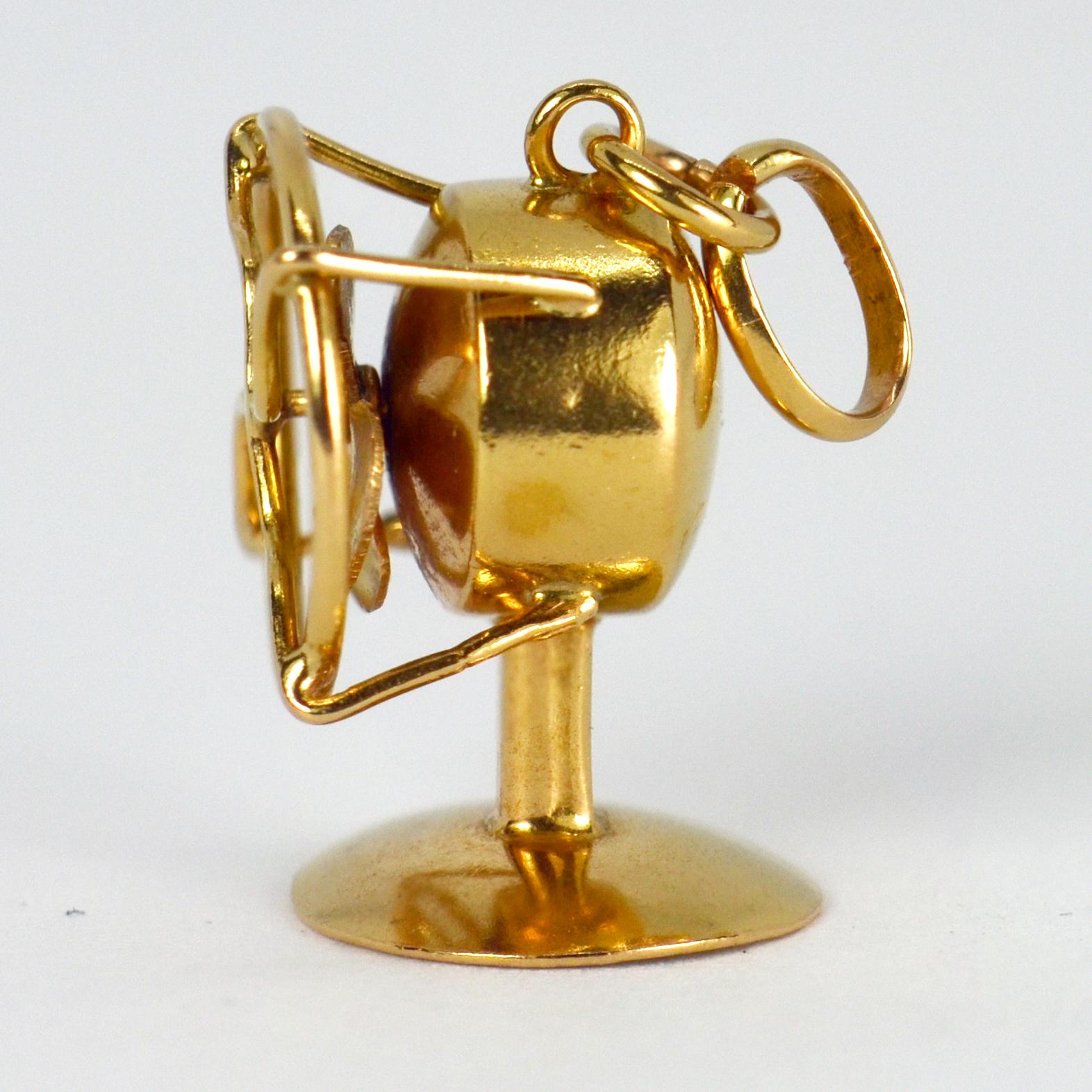 Ein Anhänger aus 18 Karat (18K) Gelbgold in Form eines mechanischen Tischventilators mit rotierenden Flügeln. Nicht gestempelt, aber auf 18 Karat Gold getestet. 

Abmessungen: 1.6 x 1,15 x 1 cm
Gewicht: 1,93 Gramm
