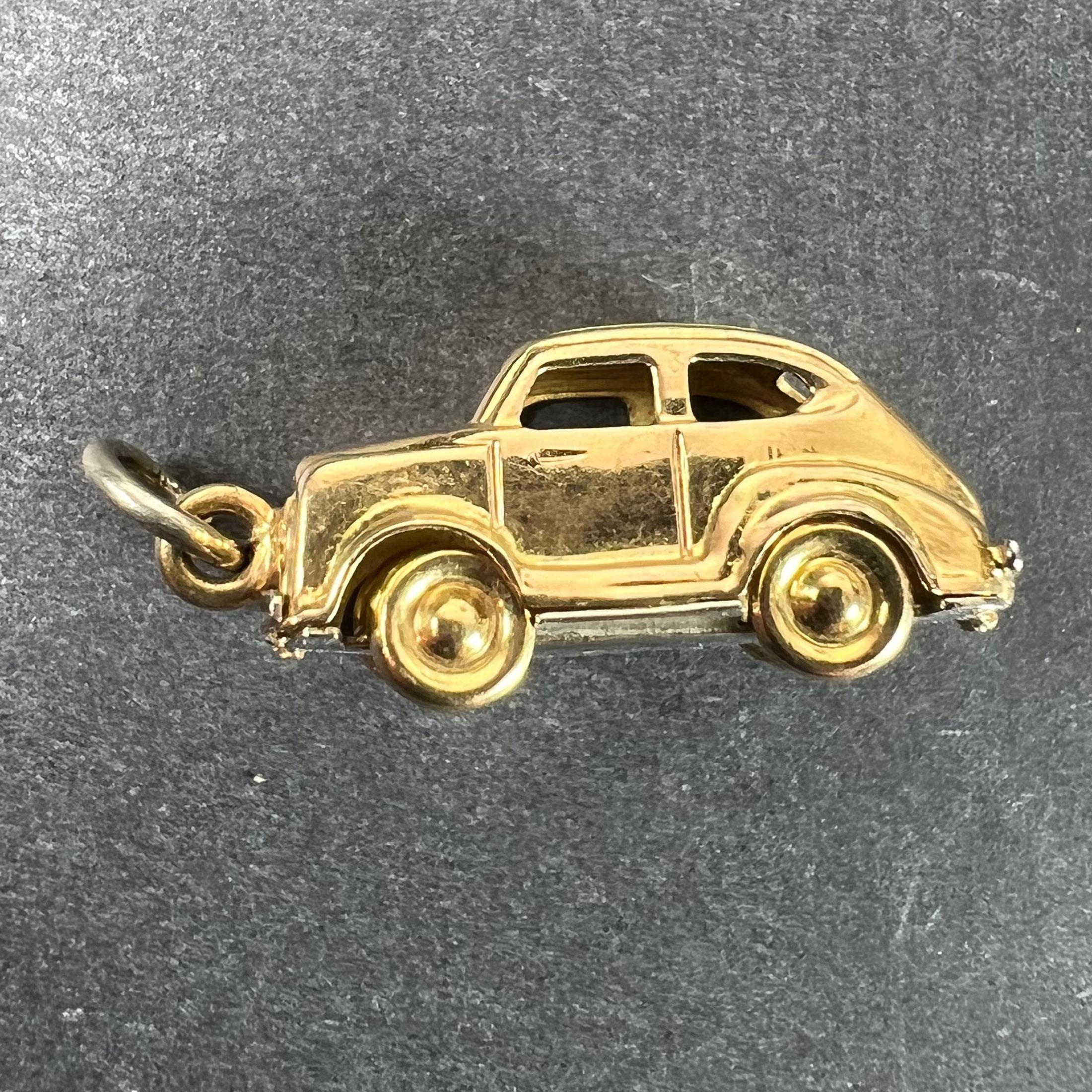Pendentif à breloques en or jaune 18 carats (18K) conçu comme une berline avec des roues en mouvement avec une base en or blanc. Estampillé 18K pour l'or 18 carats à la base.

Dimensions : 2,2 x 0,8 x 0,9 cm (sans l'anneau de saut) : 2,2 x 0,8 x 0,9
