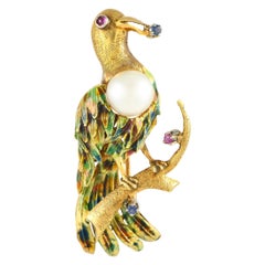 Spilla a forma di uccello in oro giallo 18K con madreperla, rubino, zaffiro e smalto