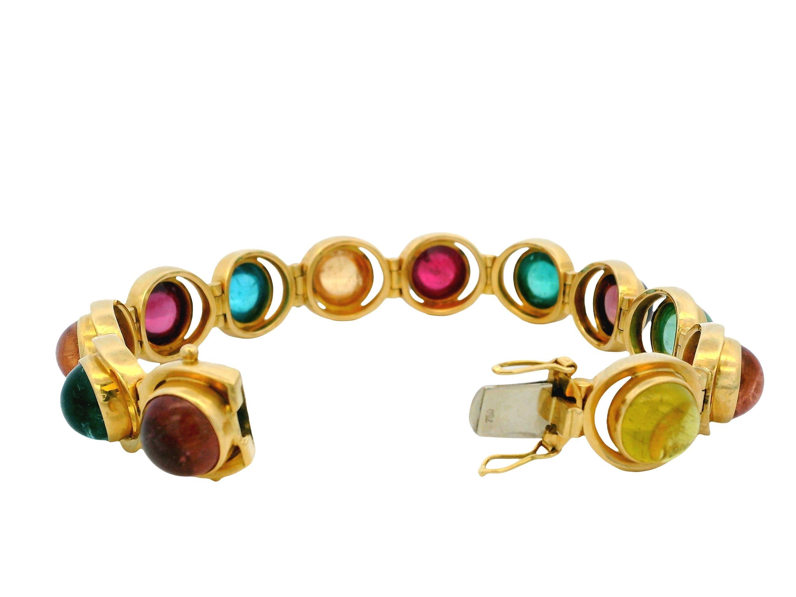 Ce bracelet exquis est fabriqué en or jaune 18 carats et présente des tourmalines multicolores en cabochon aux riches teintes vertes et rouges profondes, chacune sertie dans un chaton lisse et arrondi. Le design audacieux et coloré est rehaussé par