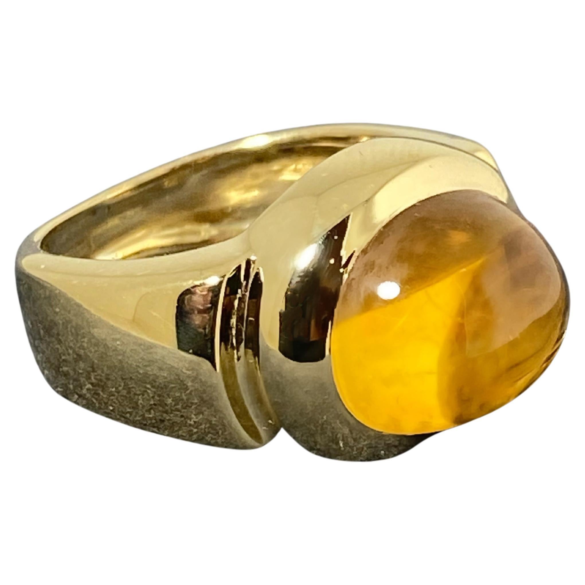 Mit einem beeindruckend großen natürlichen Citrin 
der Farbe Madeira, 
von ovaler Cabochonform,
von ca. 10,00ct, 
Maße: ca. 11 mm x 13 mm,
sicher lünettenbesetzt
aus 18K Gelbgold 

Reminiszenz an das Bulgari-Design,
der Ring ist optisch auffällig