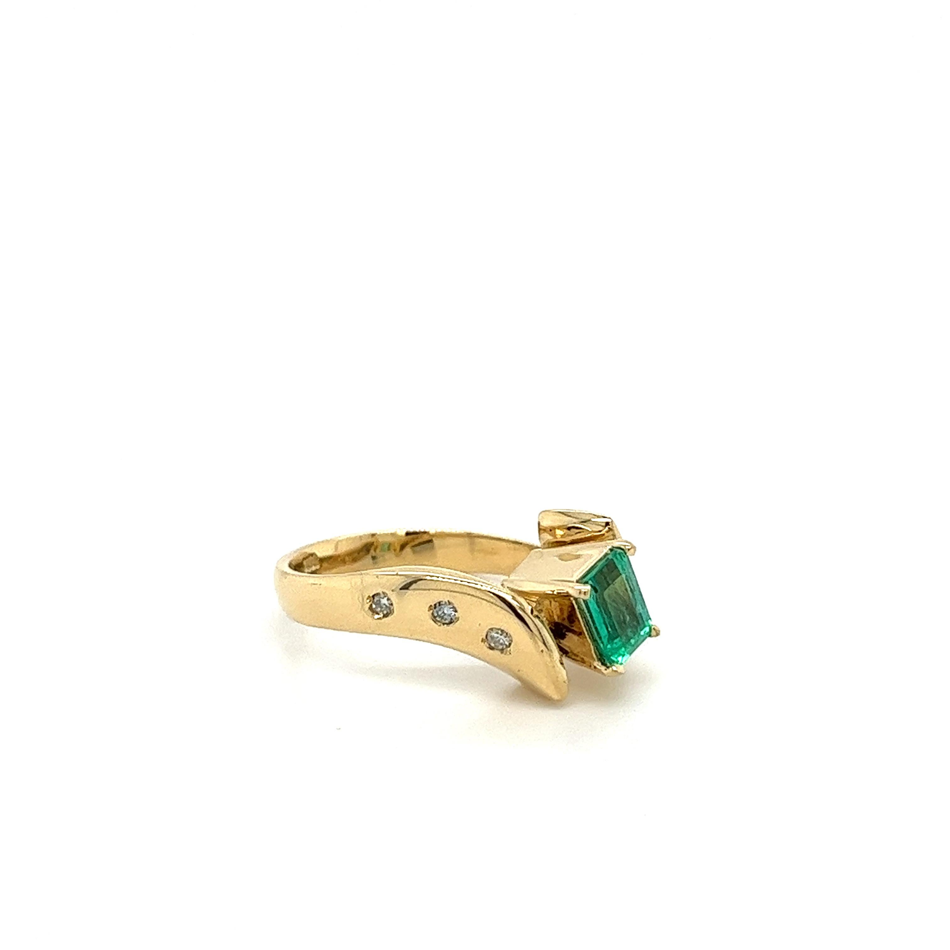 The center stone boasts a stunning 0.70-carat emerald, radiating with a captivating green hue. Surrounding the emerald, floating diamonds totaling 0.10 carats.

Set in a graceful bypass design, this ring showcases symmetrical perfection and