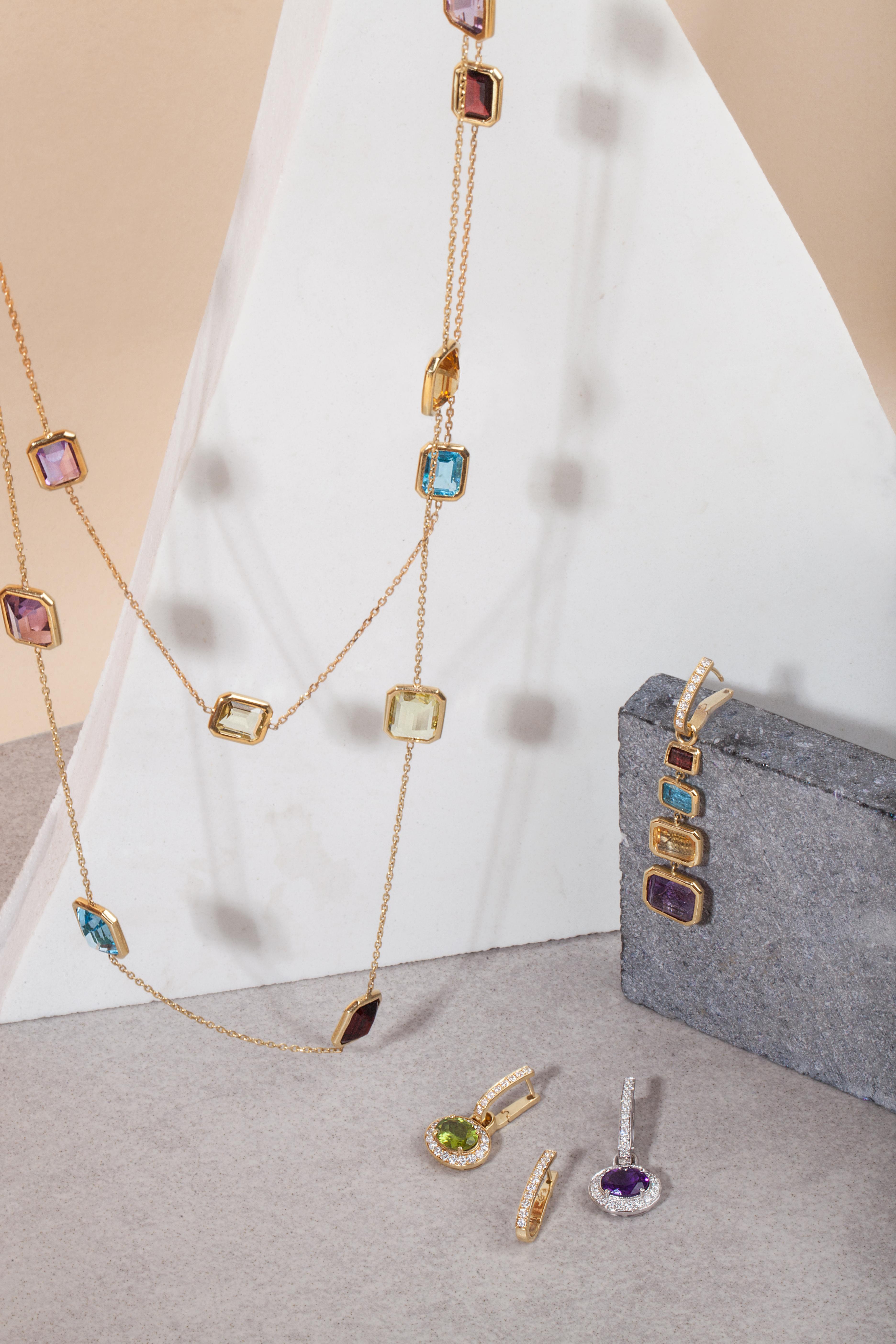 A necklace that captures and radiates daylight through its stones 
18K yellow gold Amethyst: 
– Weight (total): 8.47 carats 
– Cut: Emerald 
Citrin: 
– Weight (total): 6.81 carats 
– Cut: Emerald 
Garnet: 
– Weight (total): 8.83 carats 
– Cut:
