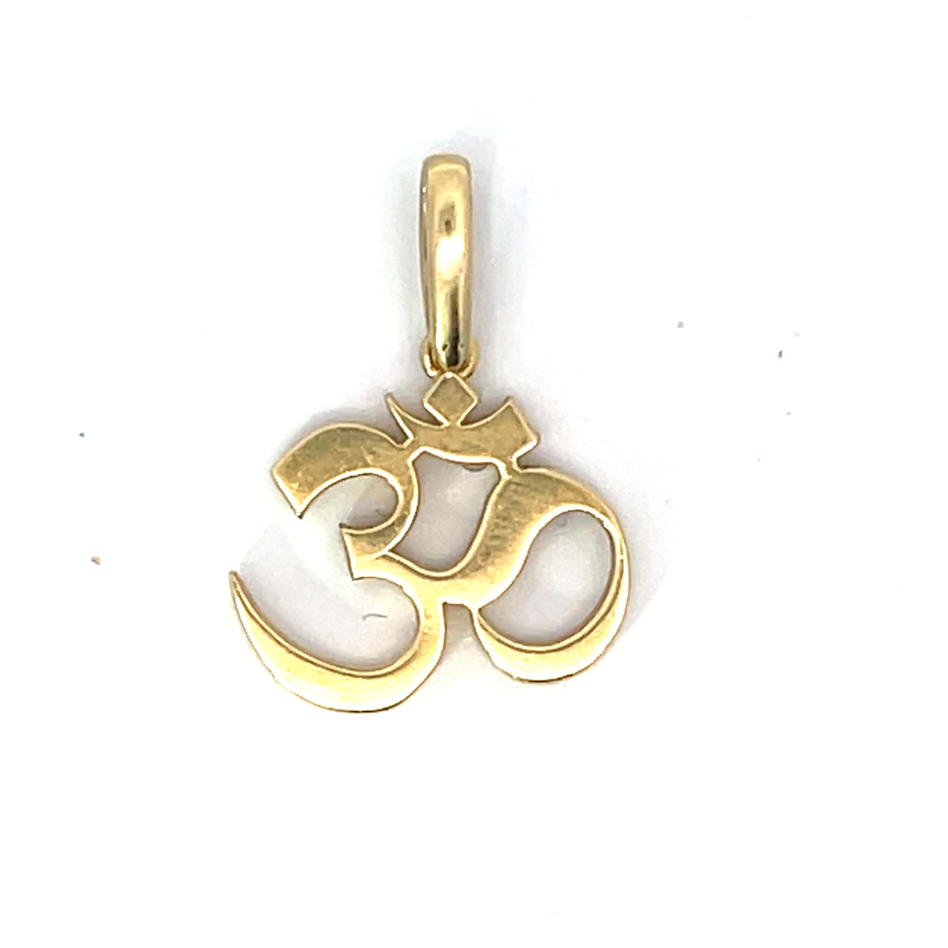 Cet exquis pendentif Om Shanti en or jaune 18 carats incarne l'élégance et la signification spirituelle. Le pendentif présente le symbole Revere, puissant emblème de paix et de tranquillité, méticuleusement réalisé en or jaune poli. Mesurant 14,90 x