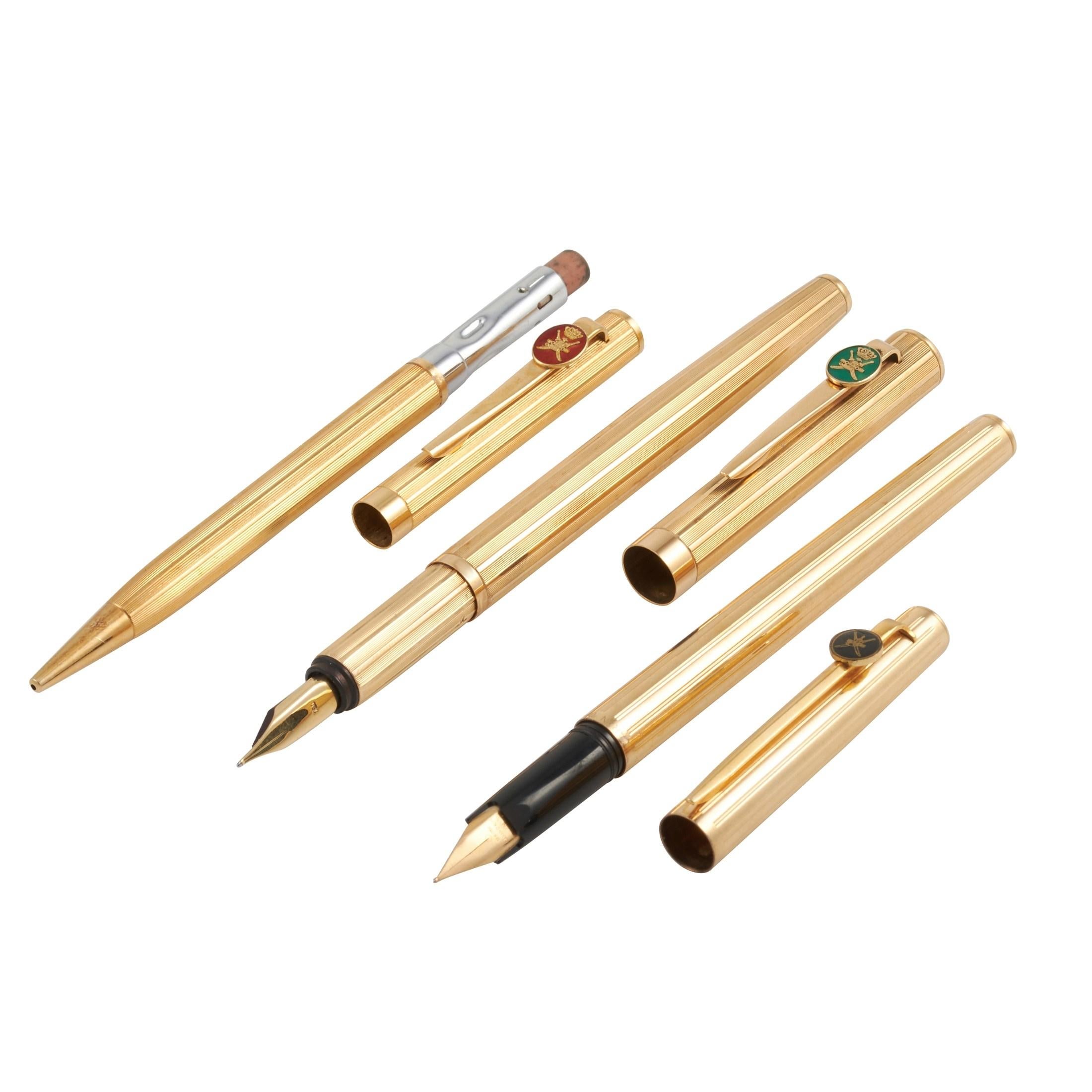 This set of three 18K yellow gold pens were made by Royama, and gifted by Sultan of Oman. Each pen features the Khanjar, the national emblem of Oman, in different colored enamel on the pen clip. One in red, one in green, and one in black. Two of the