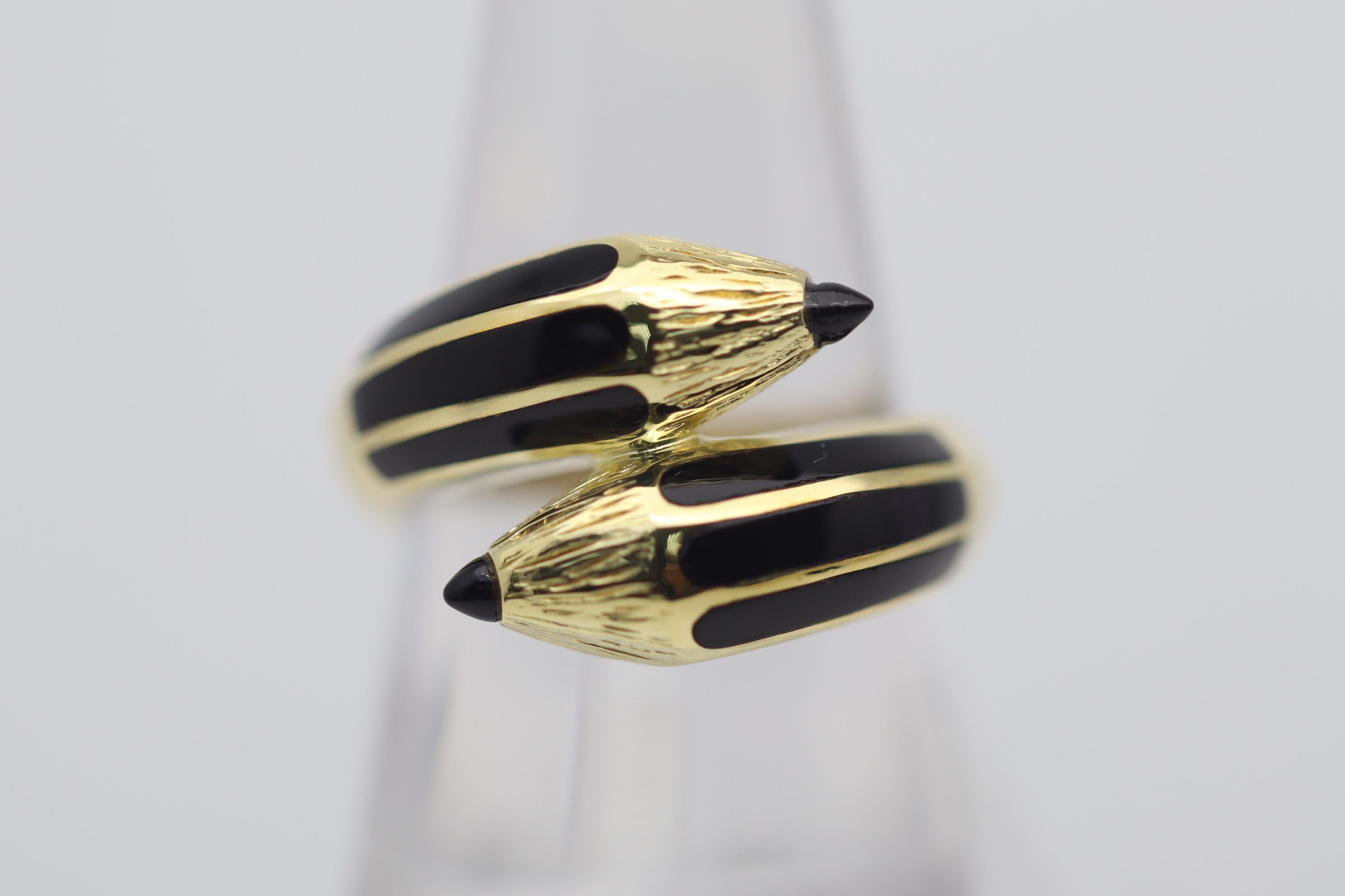 A sweet, fun and stylish ring designed as a double ended pencil! It is finely crafted in 18k yellow gold with hand-carved details making it appear lifelike. Adding to that, the pencil is enhanced with strips of black enamel and two pieces of onyx