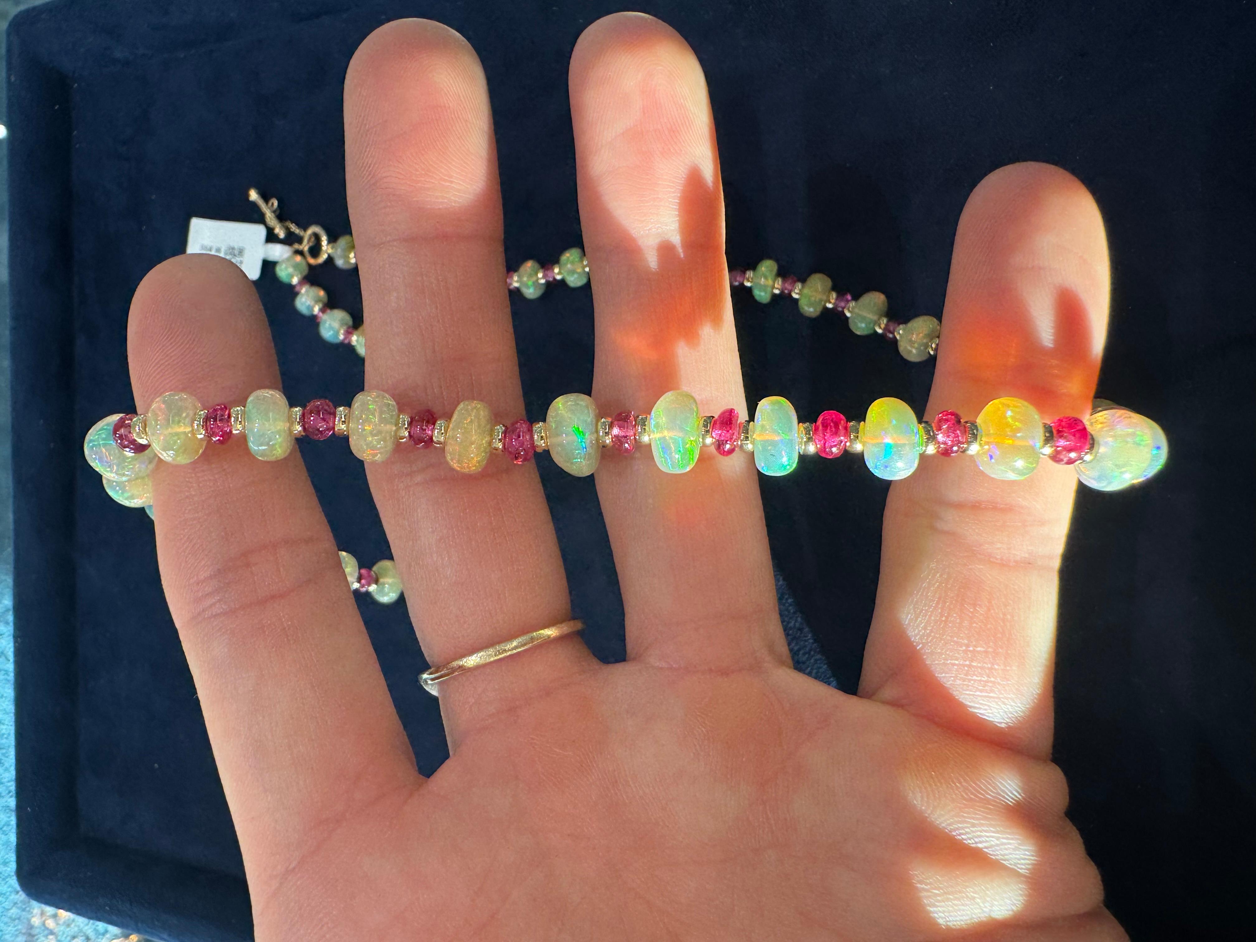 This stunning 18k yellow gold necklace is the epitome of elegance and vibrant beauty. Featuring a delicate arrangement of opal beads, each one radiates an ethereal play of colors, shifting from shimmering blues and greens to soft pinks and whites as
