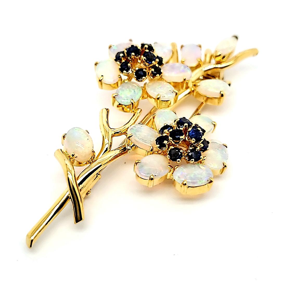 18k Yellow Gold Opal Brooch with 1.59 cts Sapphires

Fashioned from 18k gold, this extraordinary piece carries a weight of 12.6 grams, elegantly embodying the branch from which two opal flowers gracefully unfurl.

With a combined weight of 4.97