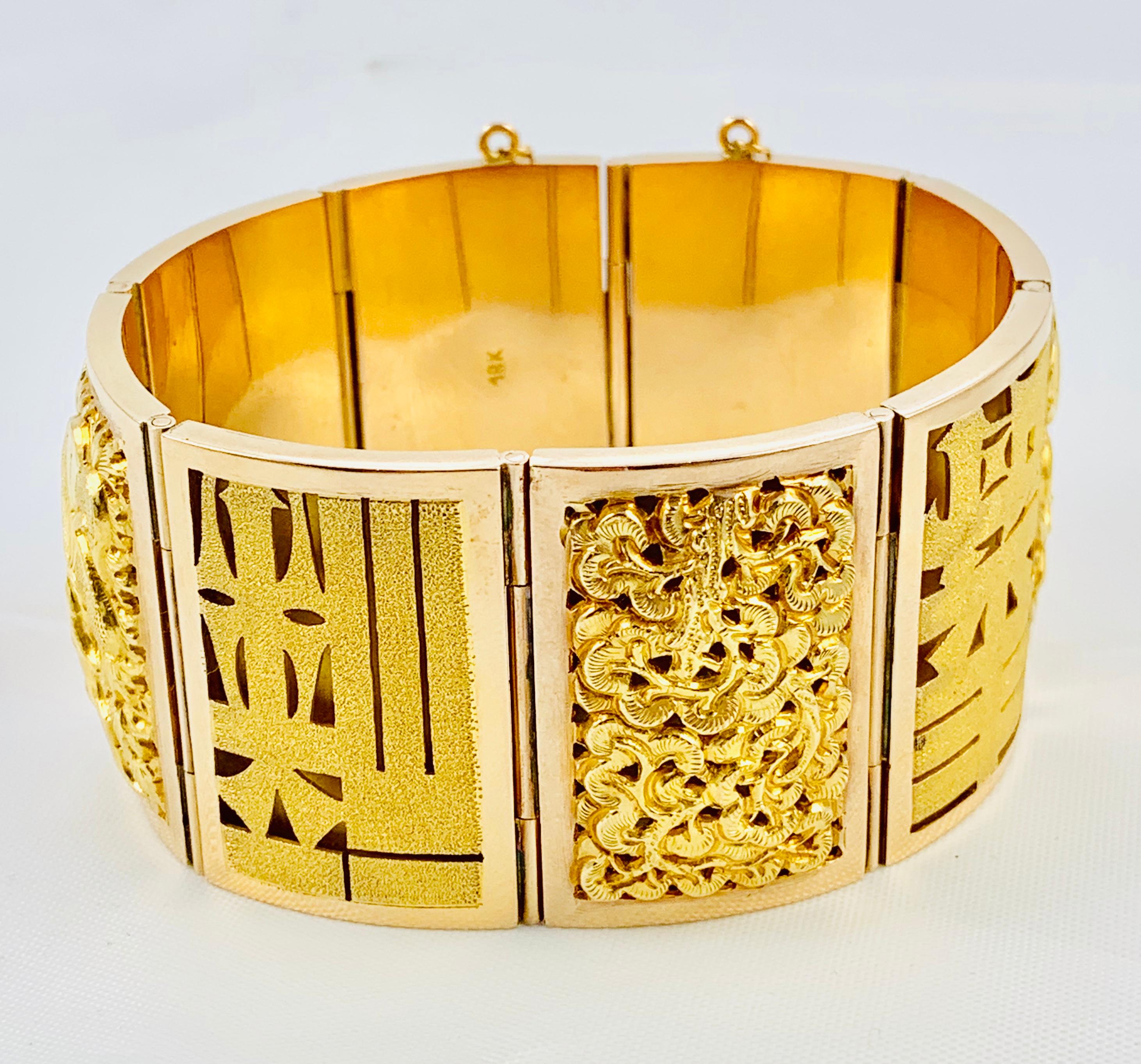 This bracelet is such a stunning piece! It is an estate bracelet made in 18K yellow Gold and features 8 sections of oriental themed plaques. This is a large bracelet that measures 1 &1/2 inches wide and weighs 98.5 grams. It is extremely comfortable