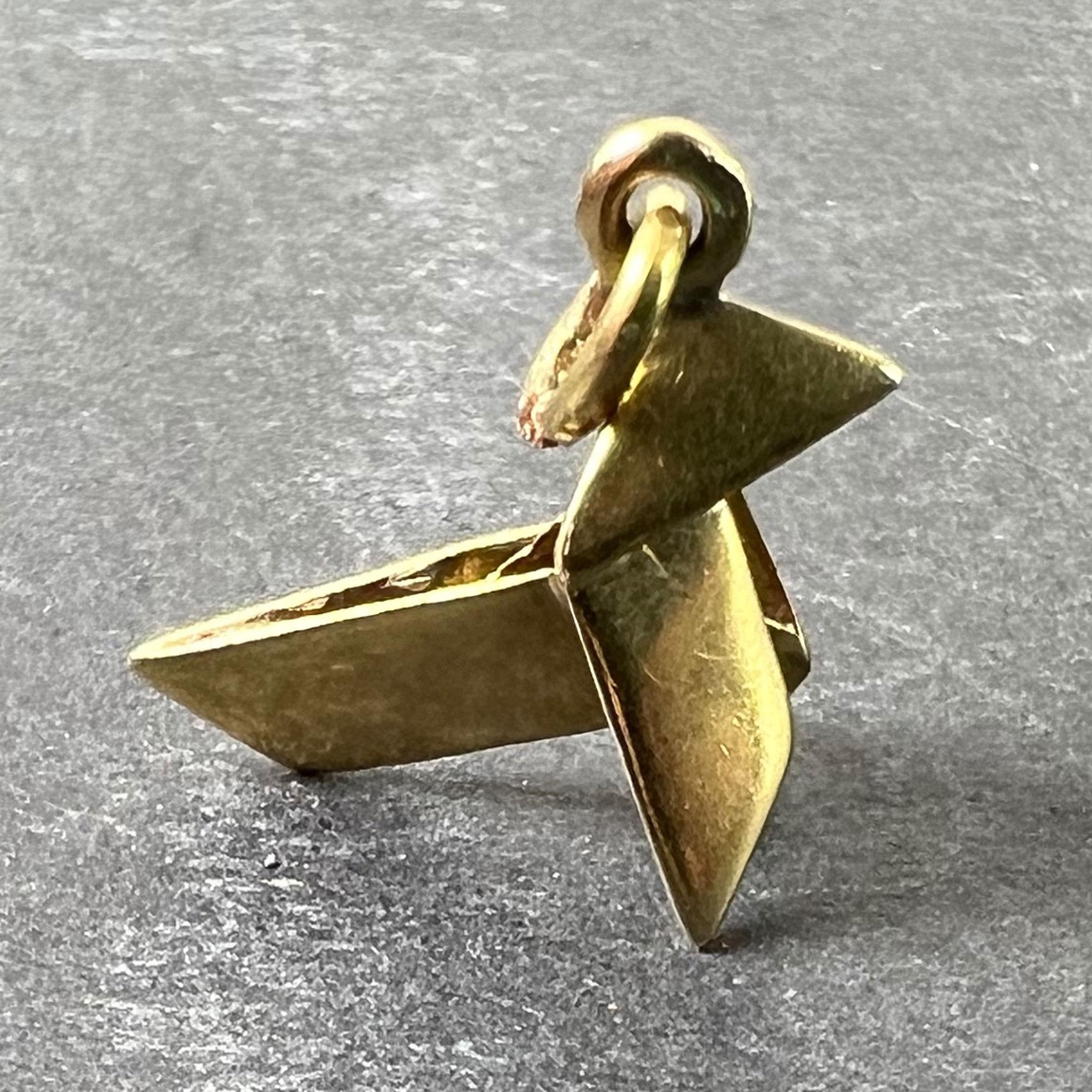 Pendentif à charme en or jaune (18 carats) conçu comme un oiseau japonais plié en origami. Non marqué mais testé comme étant de l'or 18 carats.

Dimensions : 1,5 x 1,6 x 0,75 cm (sans l'anneau de saut) : 1,5 x 1,6 x 0,75 cm (sans l'anneau de