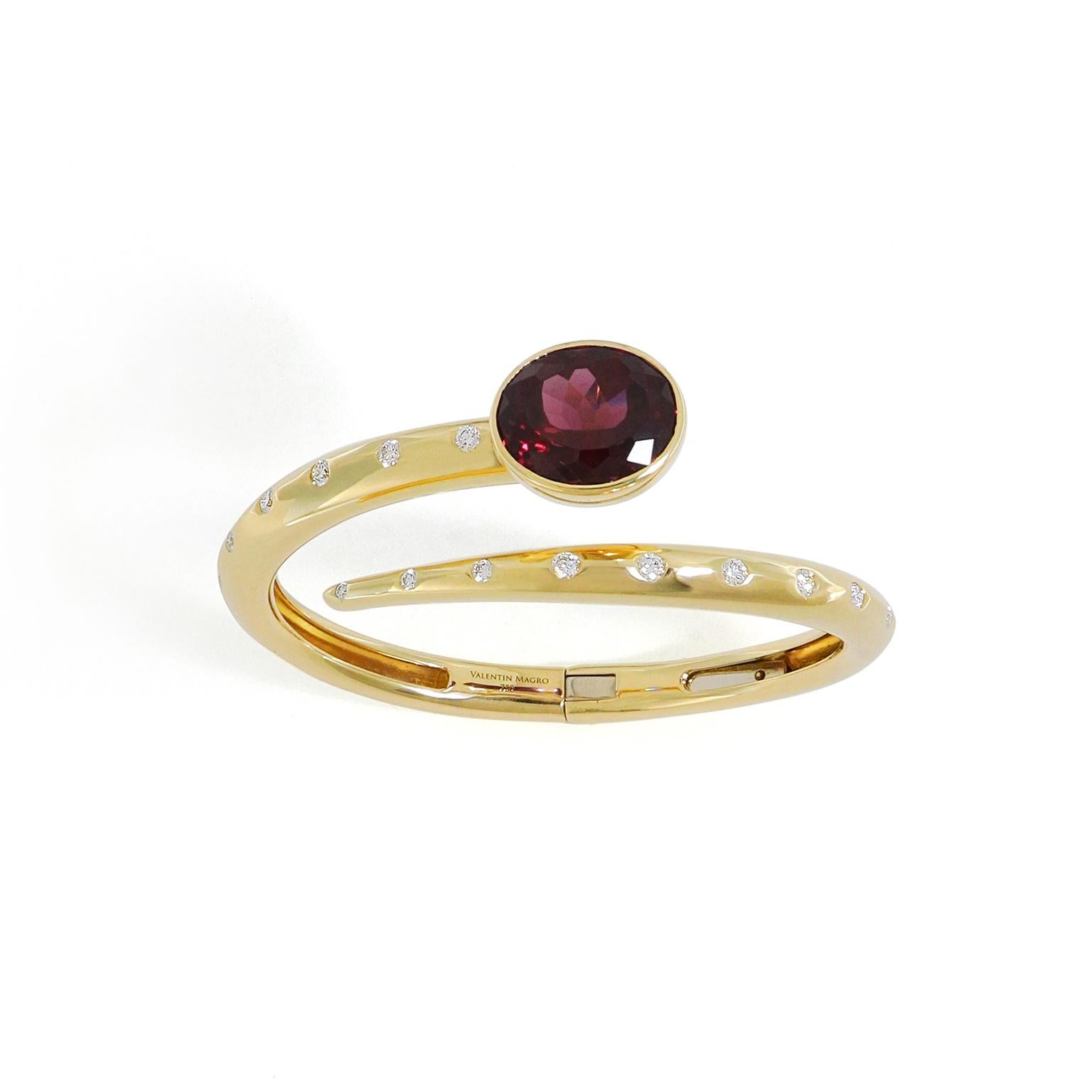 Les nuances cramoisies scintillent à travers les facettes du grenat dans ce bracelet bypass en or jaune 18 carats. Une pierre précieuse ovale sertie d'un chaton se trouve à une extrémité et s'enroule autour du centre, tandis que l'extrémité effilée