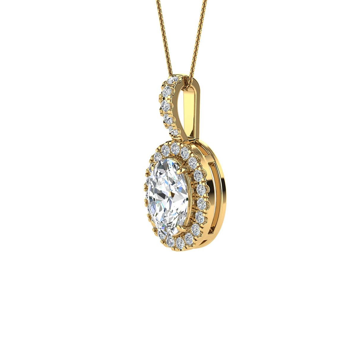 Ce délicat pendentif présente un diamant ovale d'un poids total d'environ 0,70 carat (7 mm x 5 mm) entouré d'un halo de 24 diamants ronds brillants parfaitement assortis d'un poids total d'environ 0,12 carat. Le pendentif mesure 16 mm de long et 8